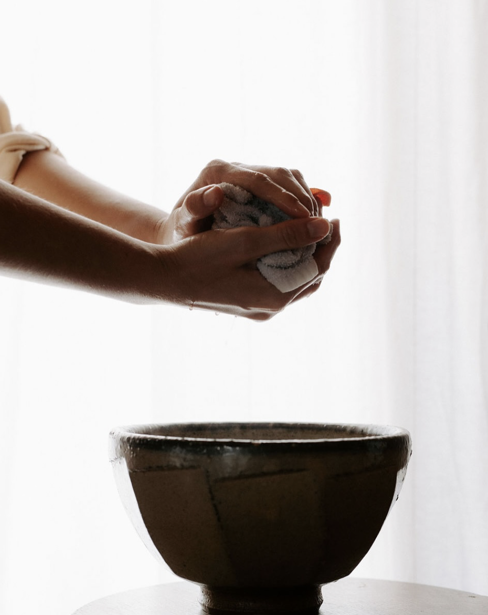 Mains lavant un bol avec un linge pour préparer un plat.