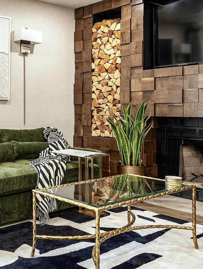 A stunning wood wall encases the fireplace in a living room design by Monique Holland.