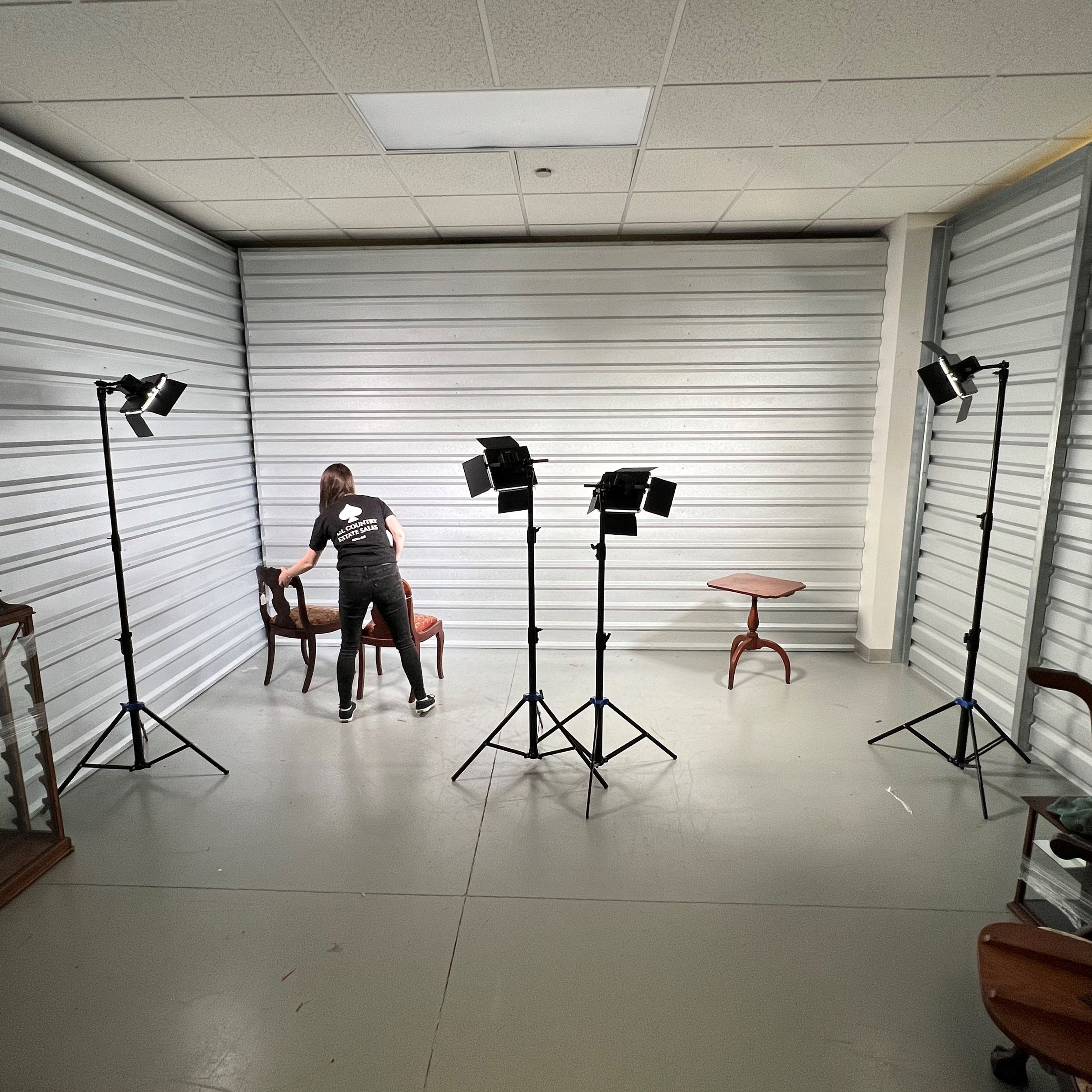 An ACES Gallery team member performing auction photography in an on-site studio setup.