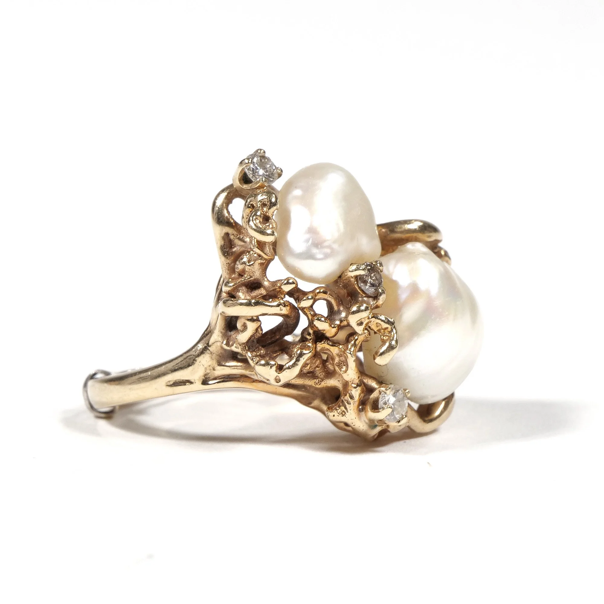 Gold ring with two large pearls and small diamonds set in an intricate, branch-like design, auctioned and photographed by ACES Gallery.