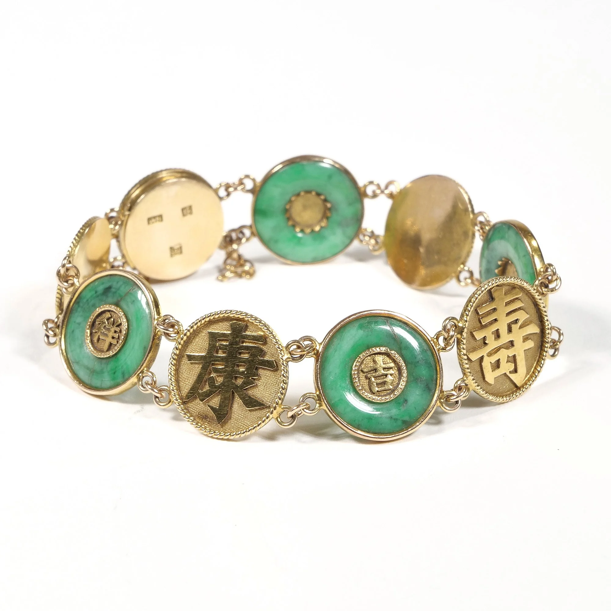 Gold bracelet with green circular stones and Chinese character, auctioned and photographed by ACES Gallery.