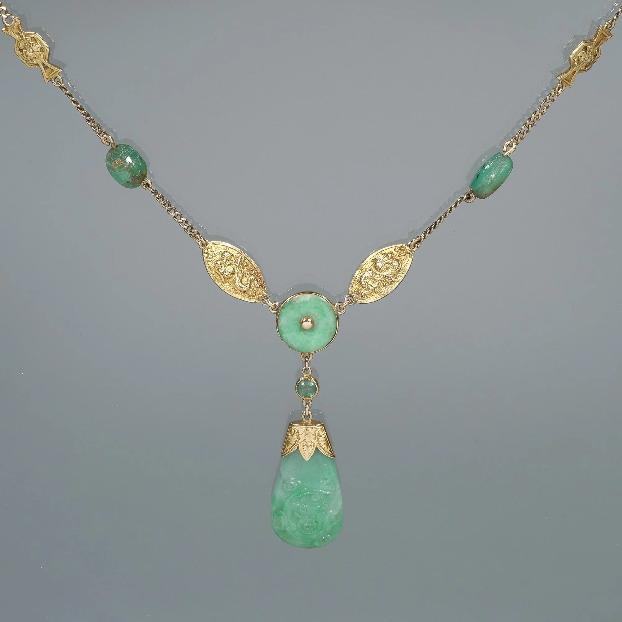 A gold necklace with green jade and intricate gold designs, auctioned and photographed by ACES Gallery.