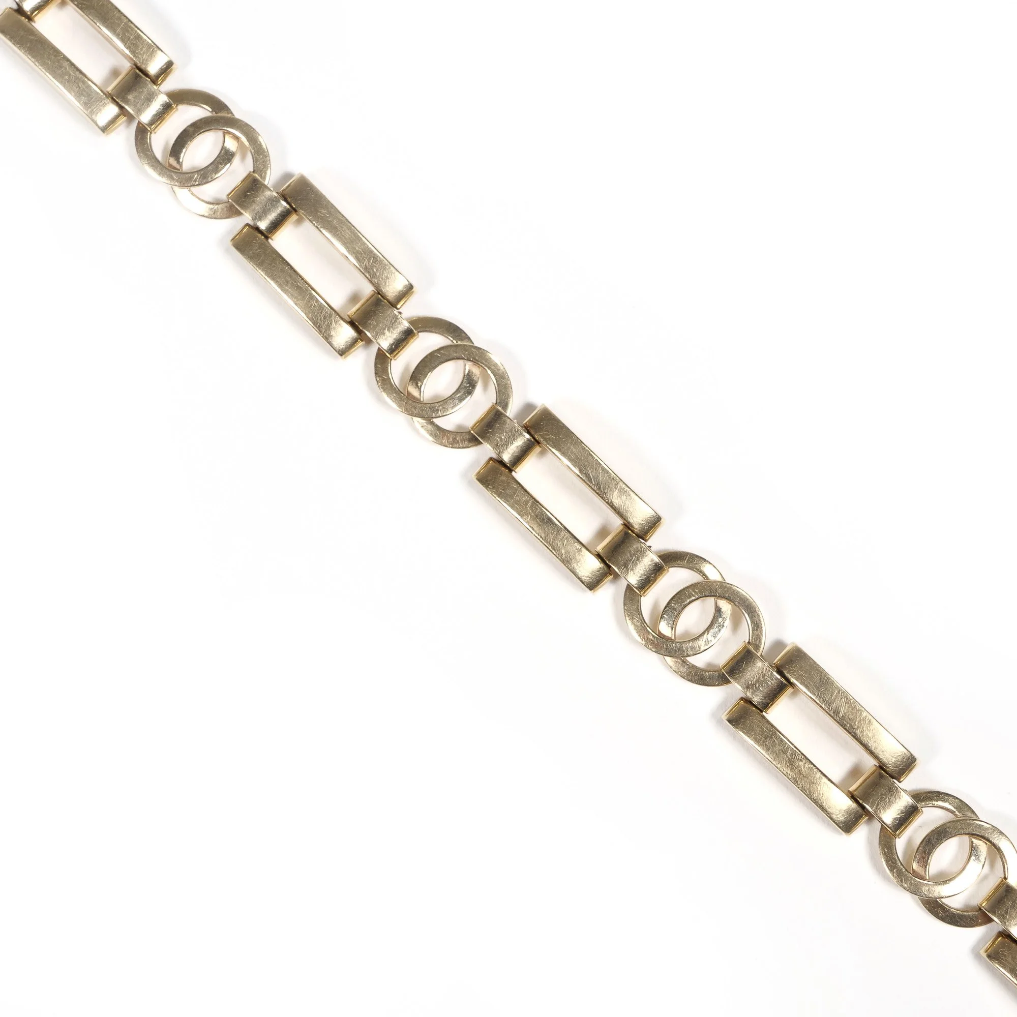 Close-up of a silver chain with rectangular links and circular loops against a white background, auctioned and photographed by ACES Gallery.