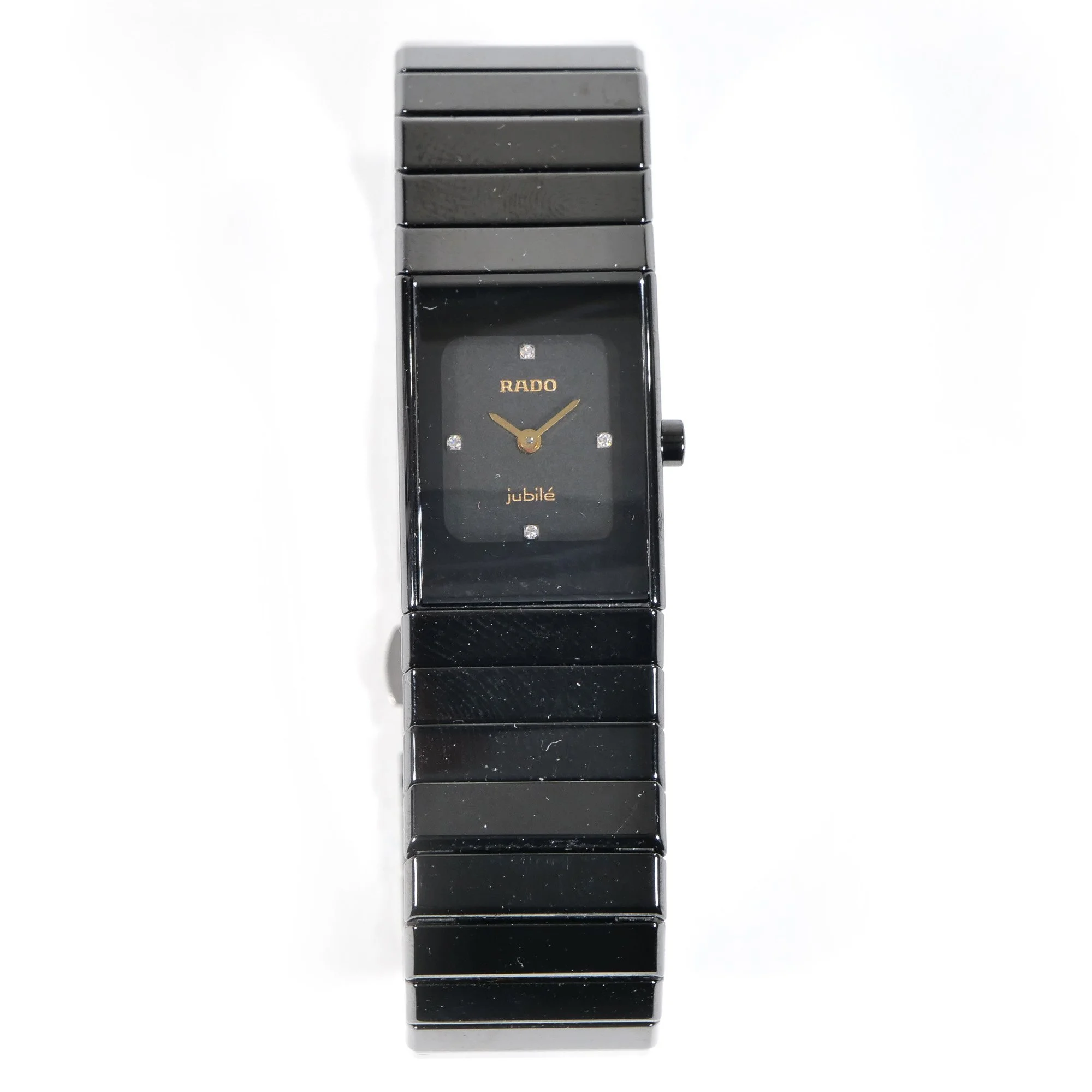 A black rectangular wristwatch with a digital display showing an analog clock face, made by RADO, with the word 'Jubilé' on the dial, set against a white background, auctioned and photographed by ACES Gallery.