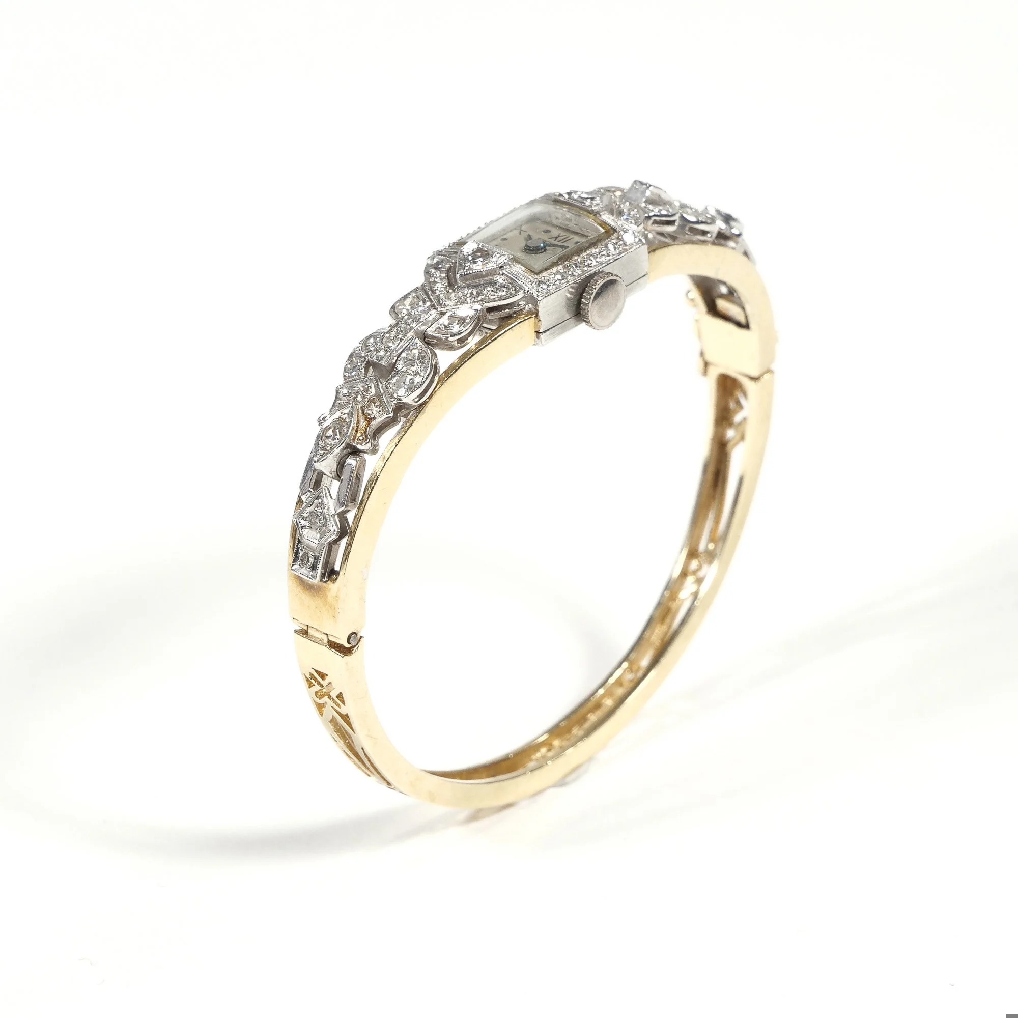 A gold and silver vintage-style wristwatch with a decorative, diamond-studded band and a small rectangular face, auctioned and photographed by ACES Gallery.