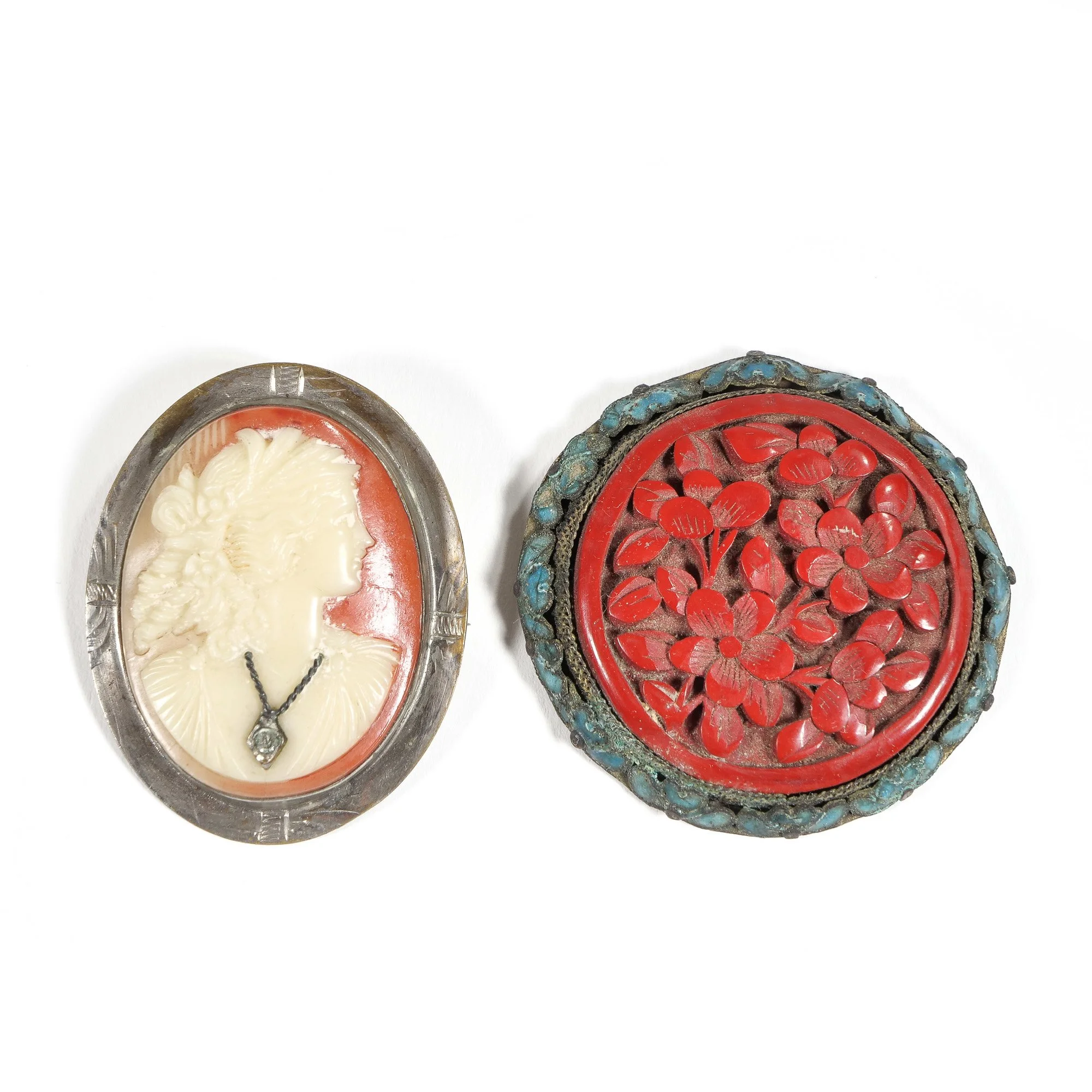 Two vintage jewelry boxes, one with a cameo of a woman's profile and the other with a floral design, both featuring ornate metal borders, auctioned and photographed by ACES Gallery.