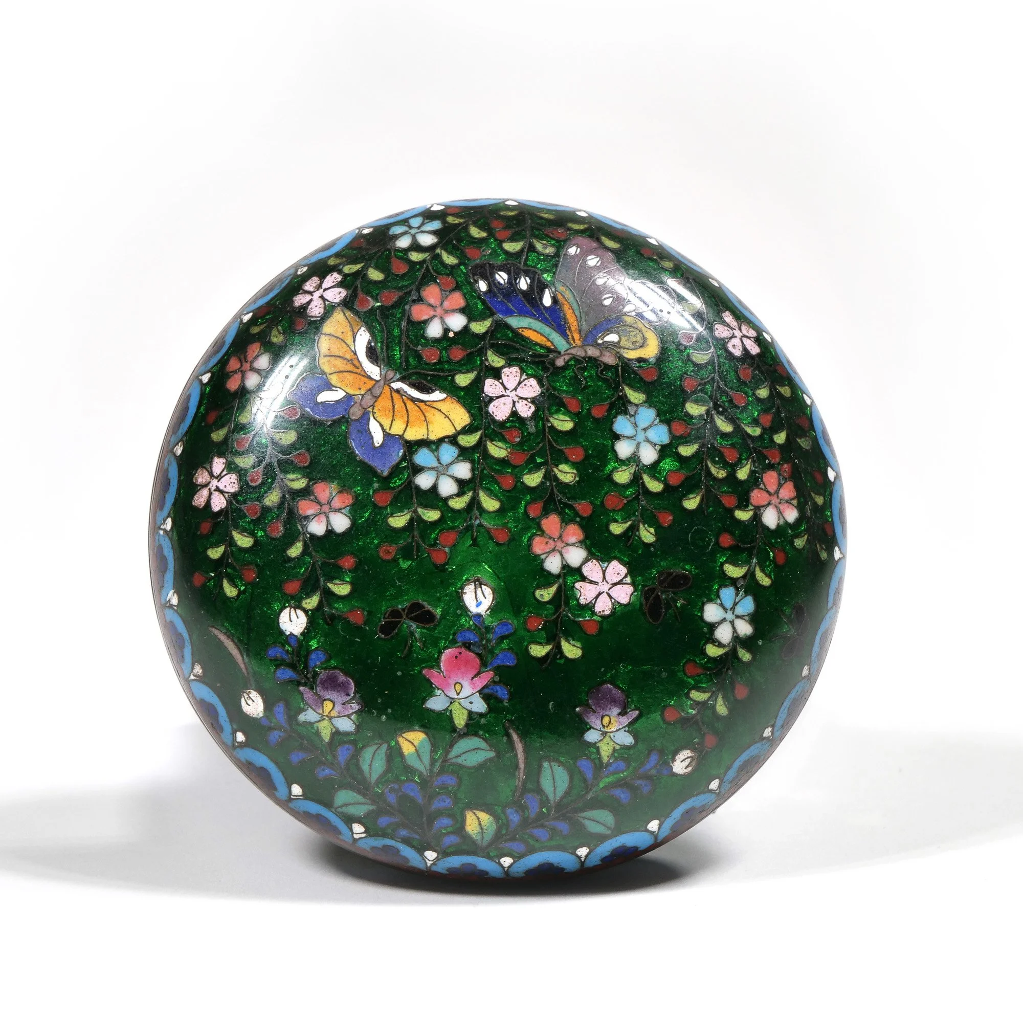 Decorative round art glass paperweight with intricate flower and butterfly pattern in vibrant colors, against a white background, auctioned and photographed by ACES Gallery.