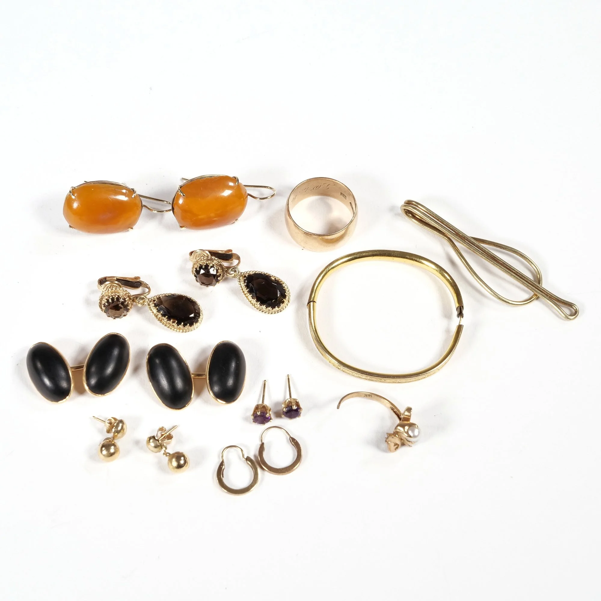 Assorted jewelry including earrings, rings, bangles, and hairpins on a white background, auctioned and photographed by ACES Gallery.