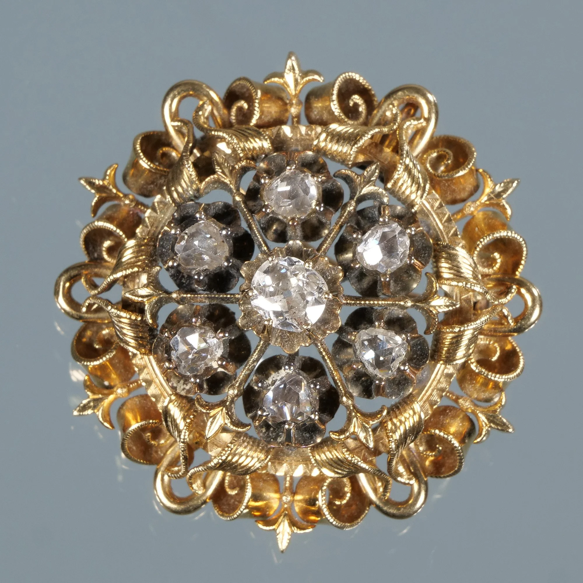 Vintage gold brooch with intricate filigree design and multiple round diamonds, auctioned and photographed by ACES Gallery.