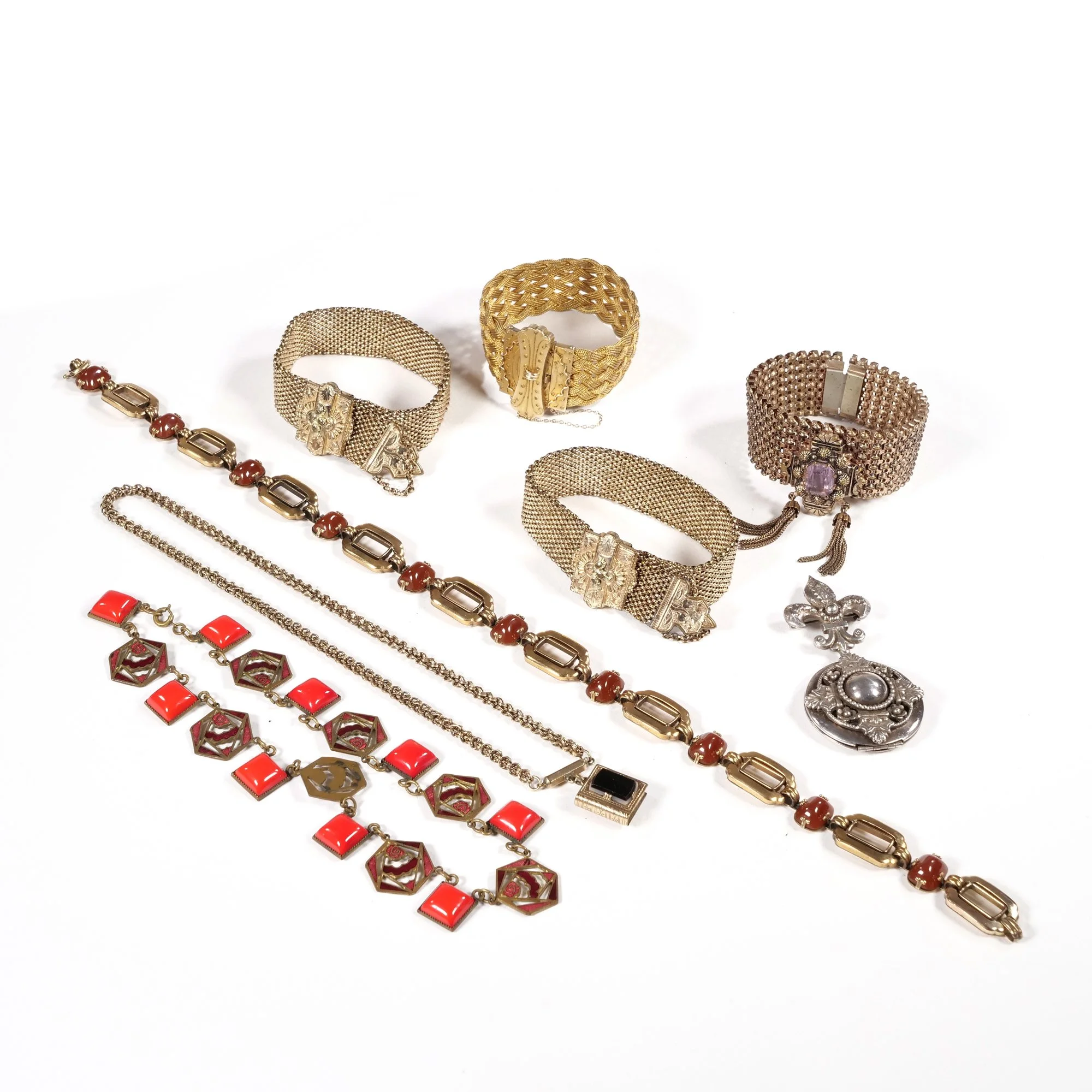 Various vintage jewelry pieces including bracelets, necklaces, and brooches on a white background, auctioned and photographed by ACES Gallery.