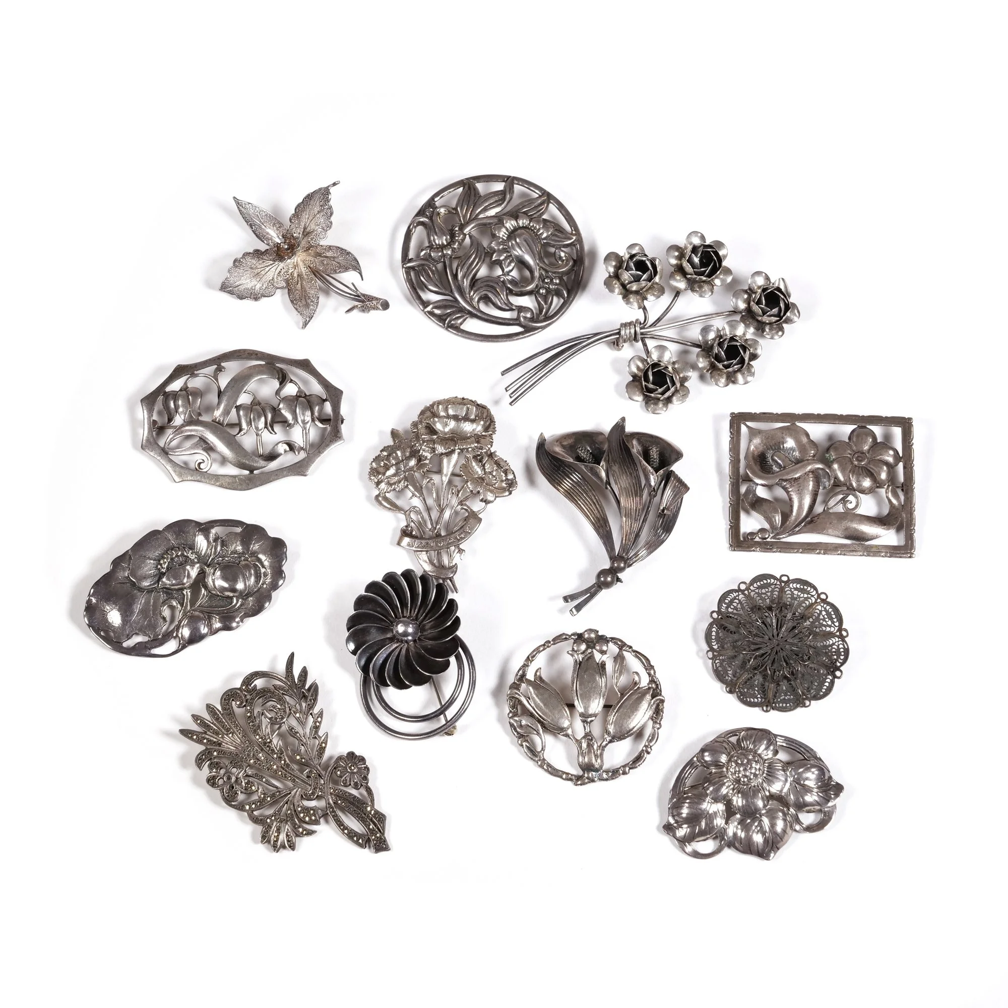 A collection of vintage silver brooches and pins with floral and nature designs, auctioned and photographed by ACES Gallery.