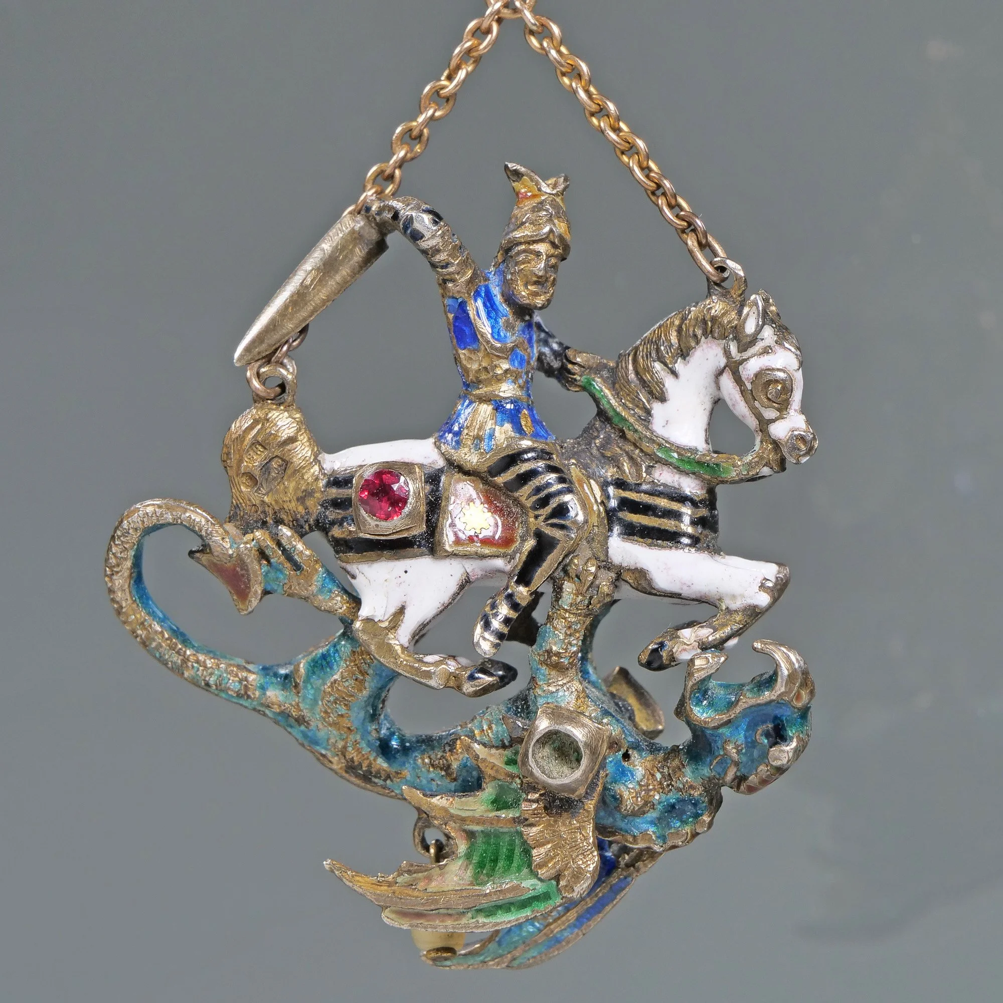 Colorful pendant featuring a knight riding a horse, adorned with gemstones and enamel detailing, on a chain, auctioned and photographed by ACES Gallery.