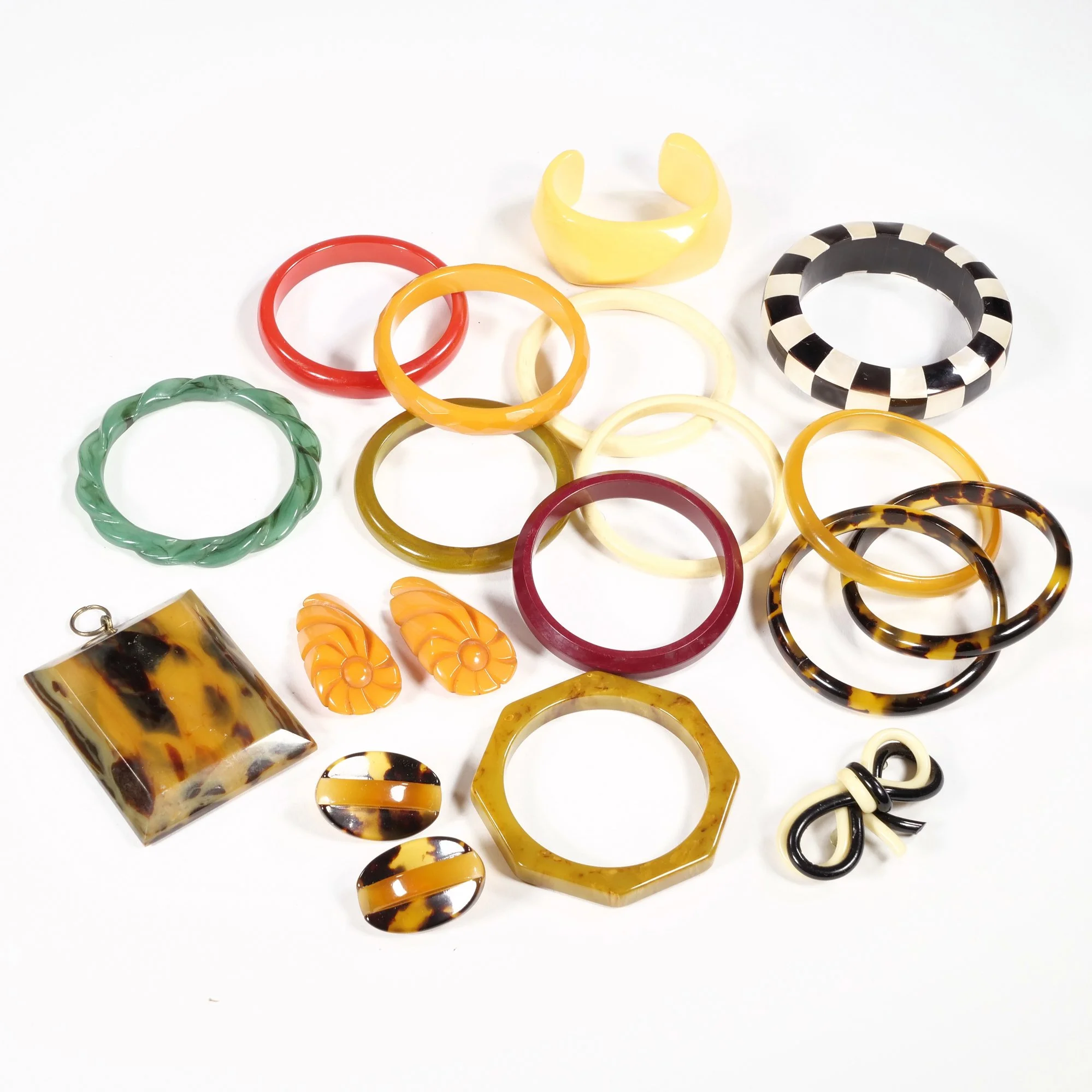 Collection of colorful plastic and resin bangles and earrings on a white background, auctioned and photographed by ACES Gallery.