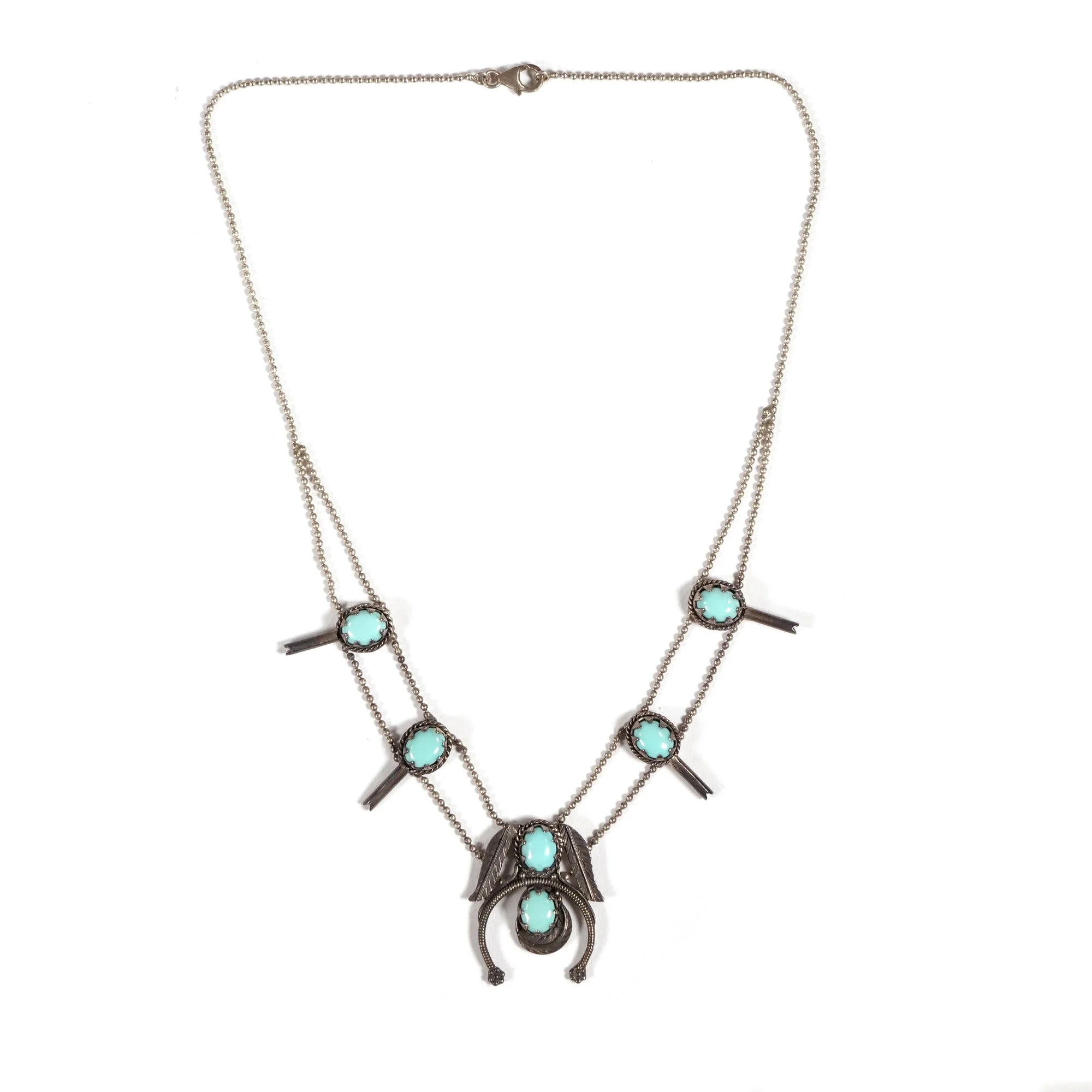 Silver squash blossom necklace with multiple turquoise stones and vertical metal bar accents on a white background, auctioned and photographed by ACES Gallery.