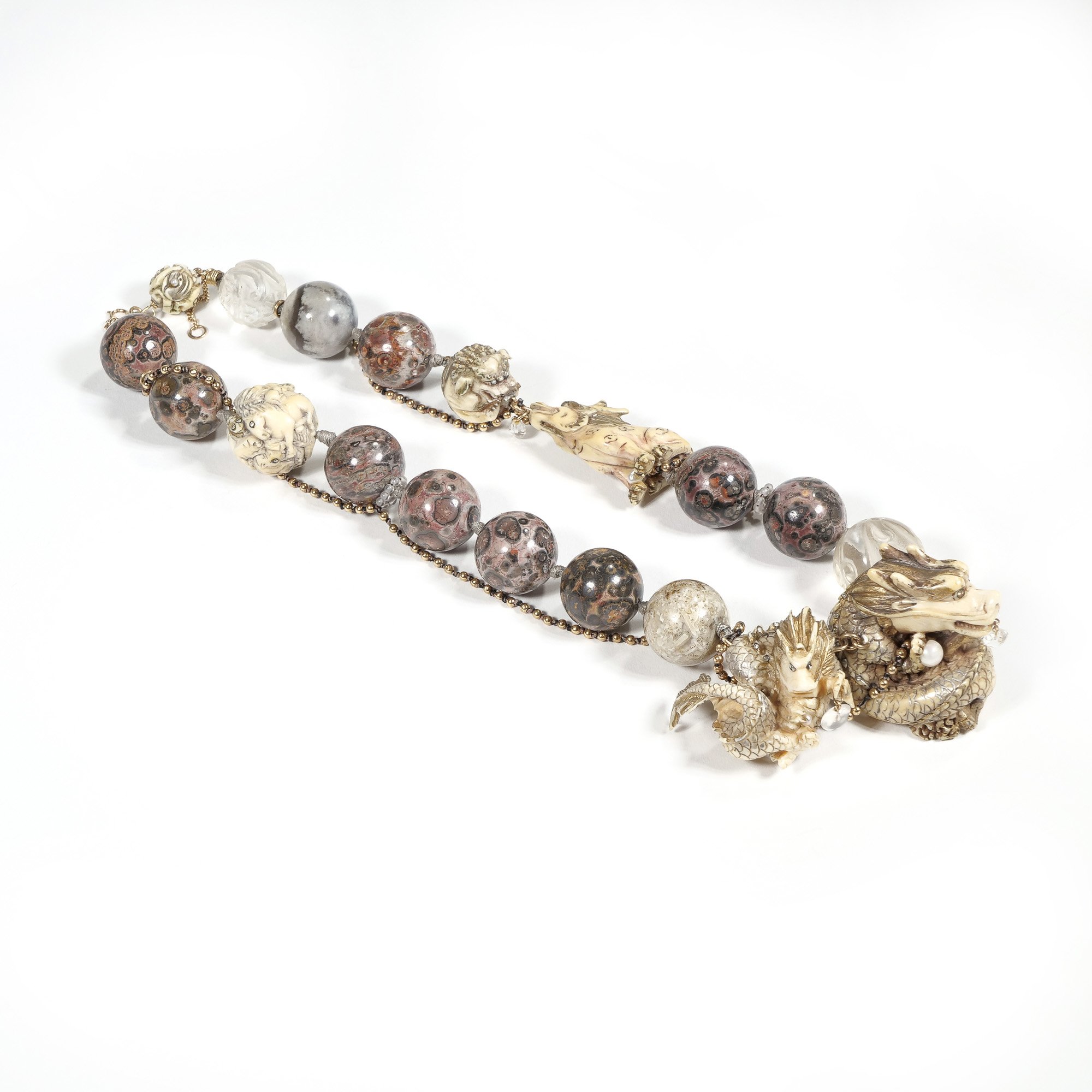 Decorative stone beaded necklace with dragon and pearl motifs on a white background, auctioned and photographed by ACES Gallery.