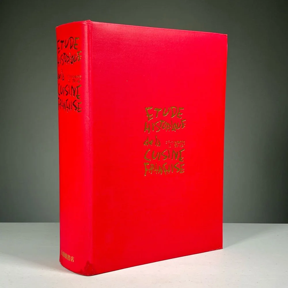 A red hardcover book titled 'Etude Historique de la Cuisine Parfaite' with gold lettering, standing upright against a neutral background, auctioned and photographed by ACES Gallery.
