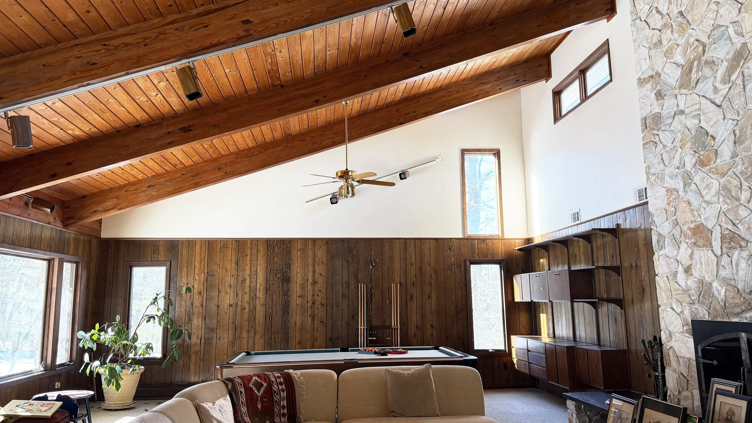 A mid-century modern great room with vaulted wood paneled ceiling