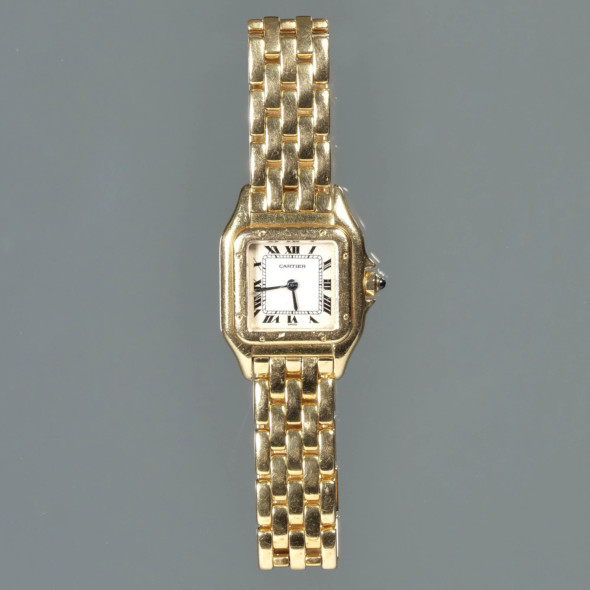 A lady's gold Cartier wristwatch with a rectangular face and Roman numerals, auctioned and photographed by ACES Gallery.