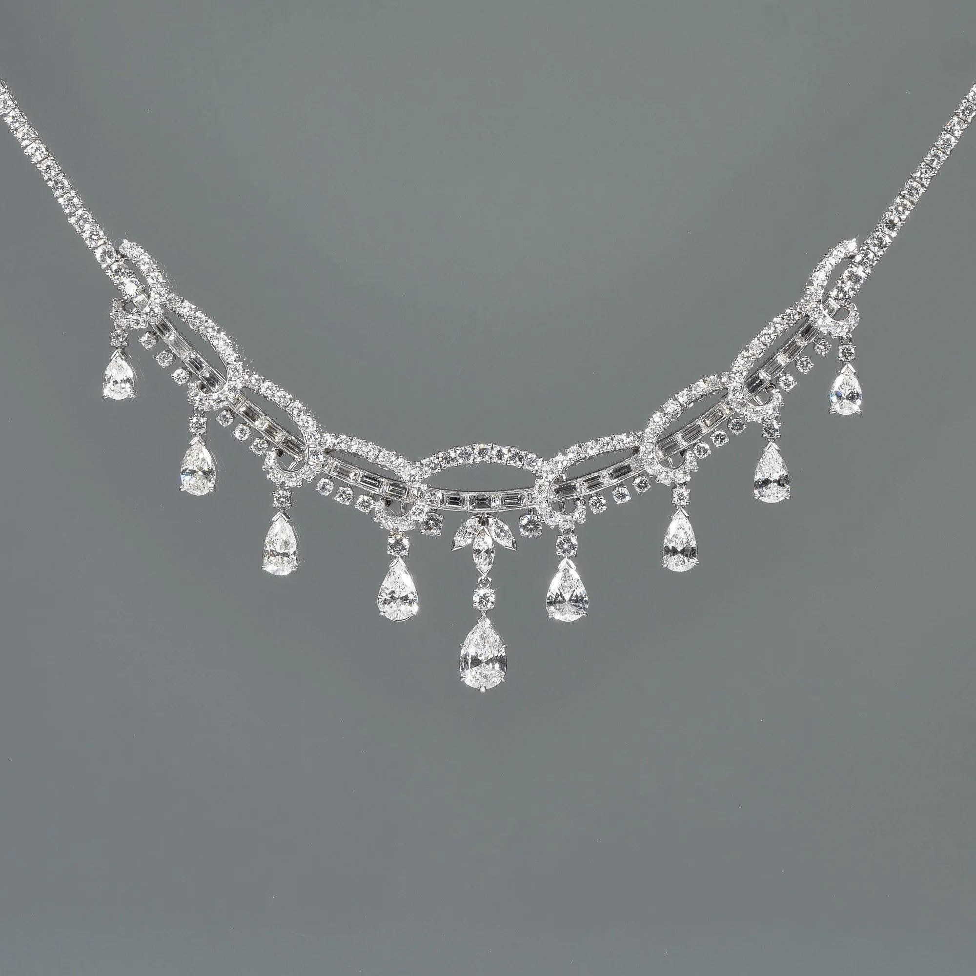 A diamond festoon necklace with multiple dangling teardrop-shaped diamonds, auctioned and photographed by ACES Gallery.
