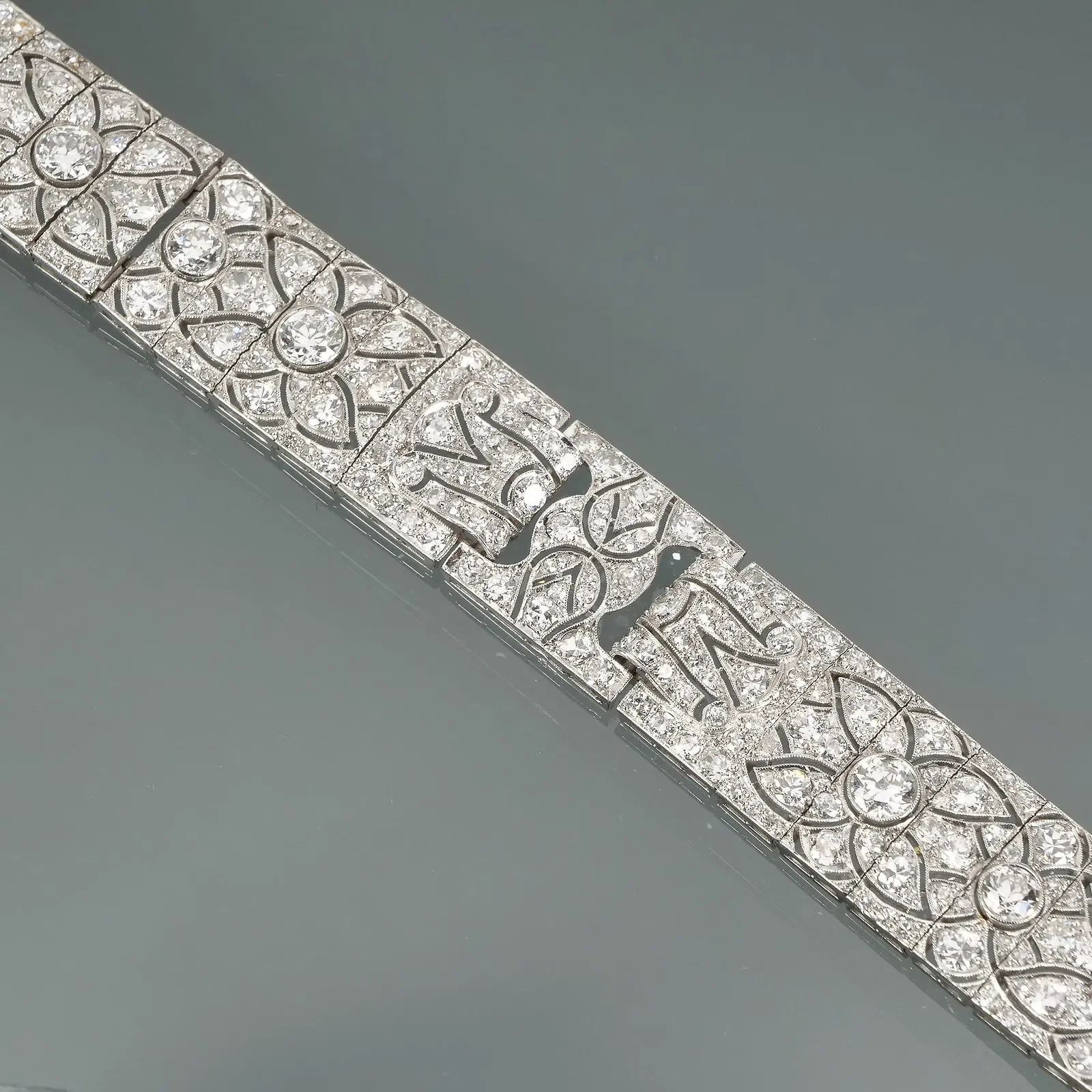 An art deco diamond and platinum braceletfeaturing intricate floral and filigree designs, auctioned and photographed by ACES Gallery.
