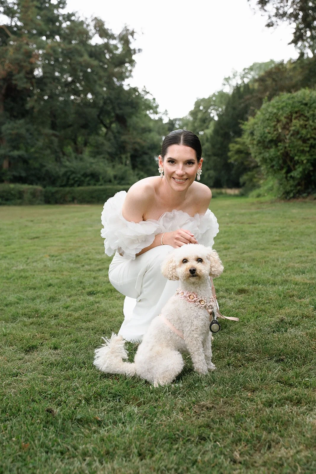 Editorial Braut kniend mit Pudel in einem Park