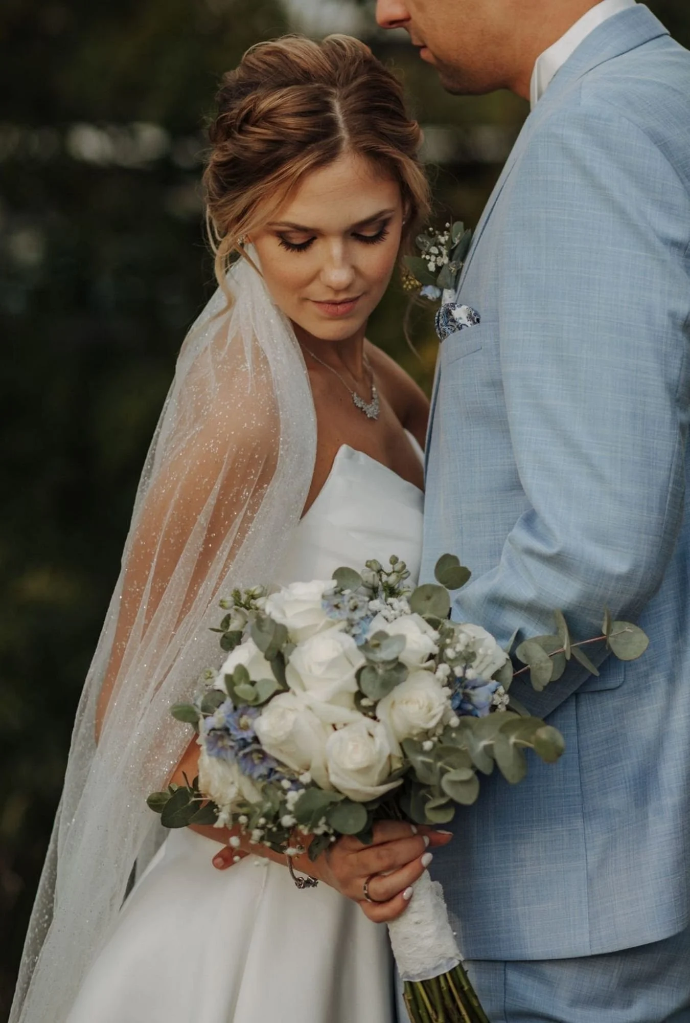 Braut mit Schleier und Brautstrauss und Bräutigam 