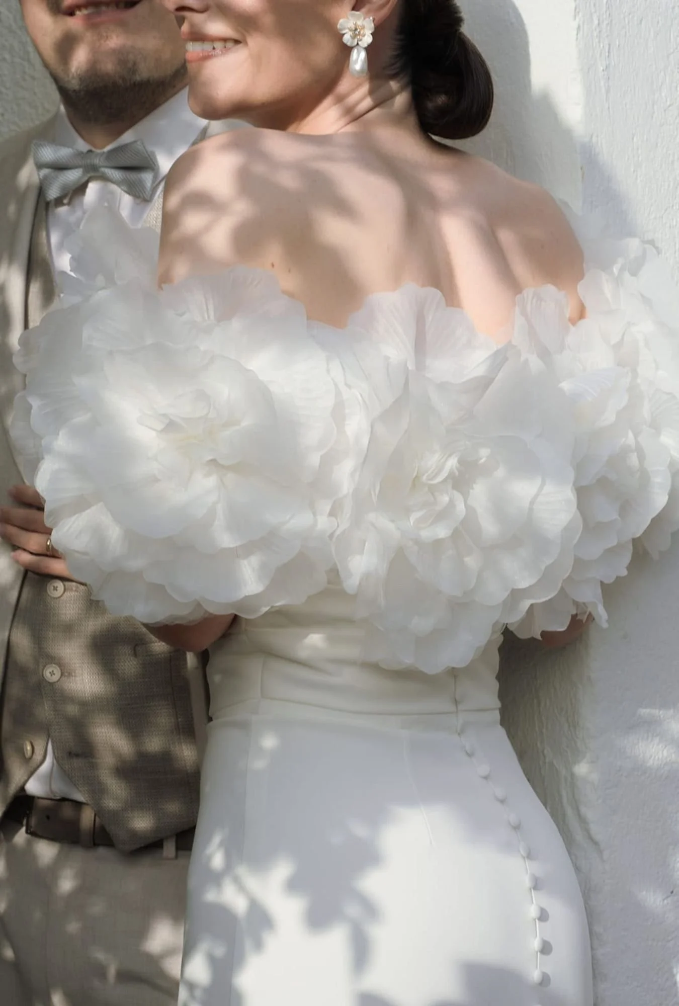 Brautpaar mit Brautkleid mit Stola aus großen Blüten 