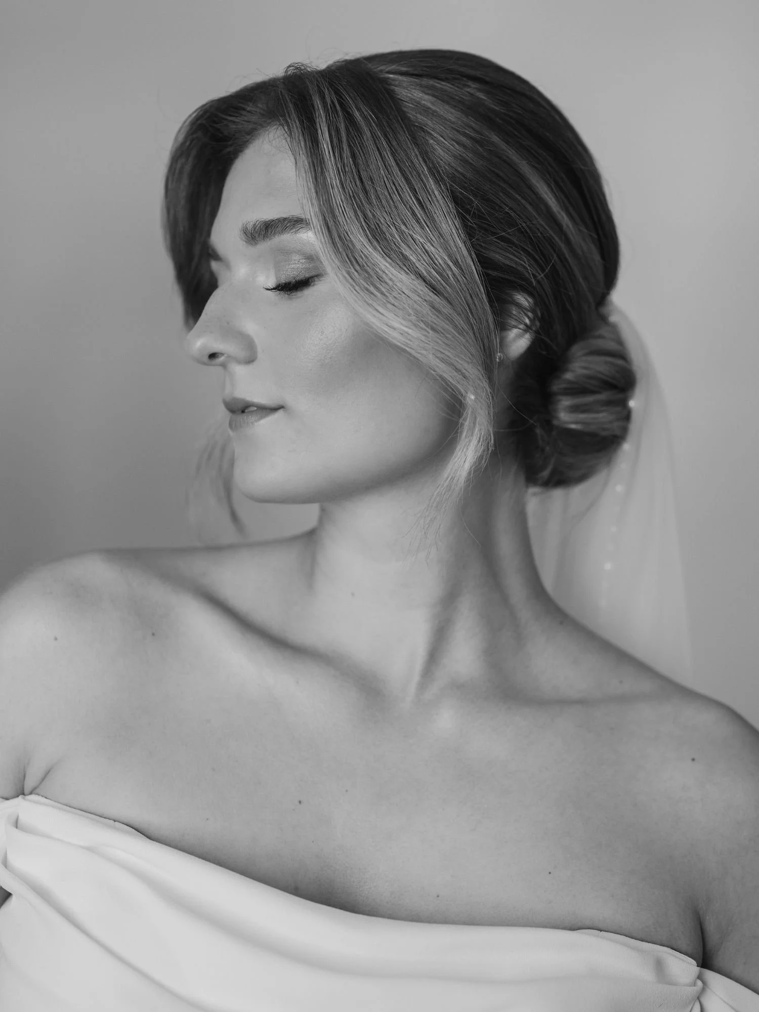 Schwarzweiß Foto von einer Braut mit elegantem Haarstyling und Schleier