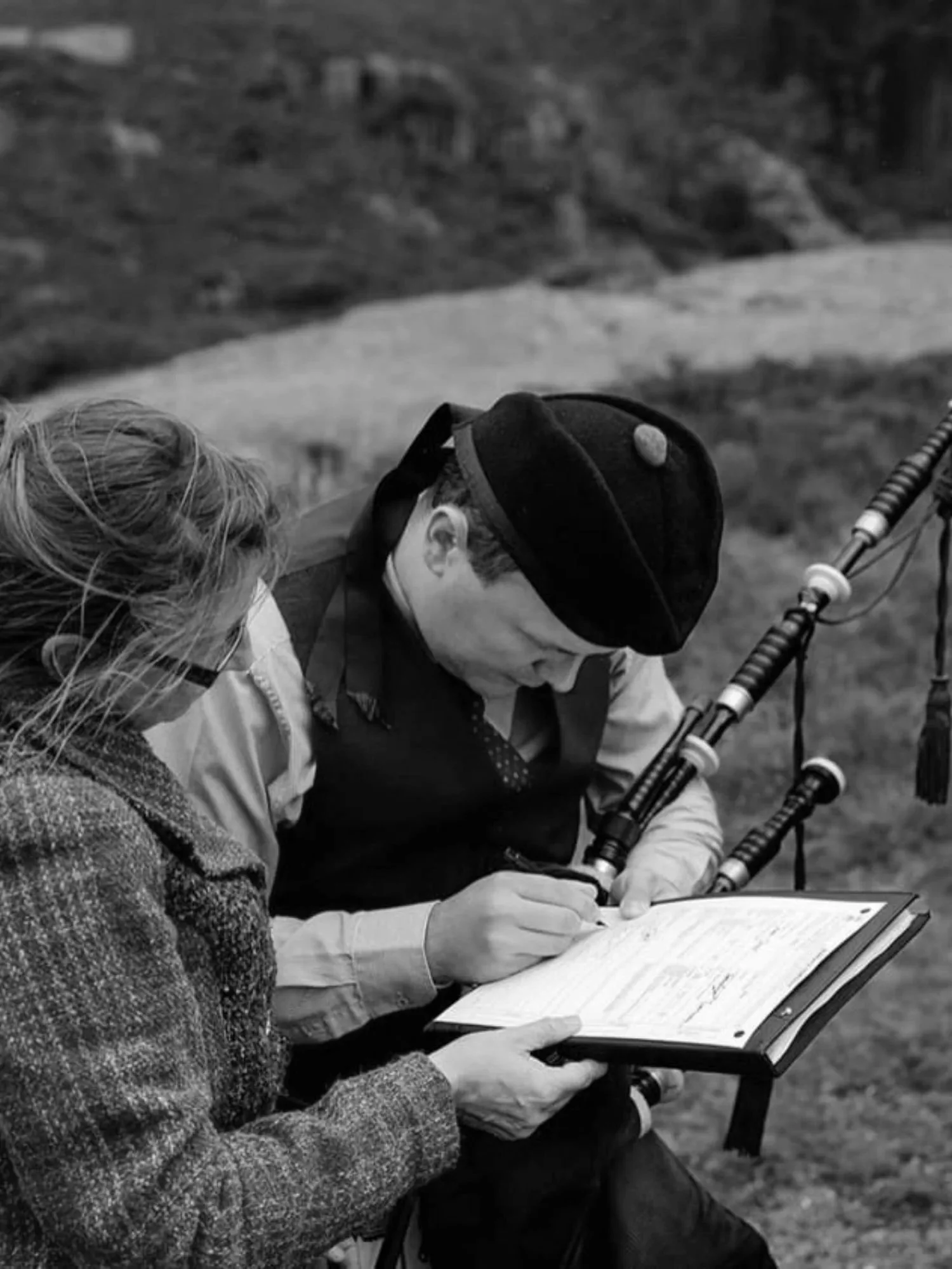 Dudelsackspieler unterzeichnet als Trauzeuge das Marriage Schedule neben Traurednerin Monika Strell in Schottland