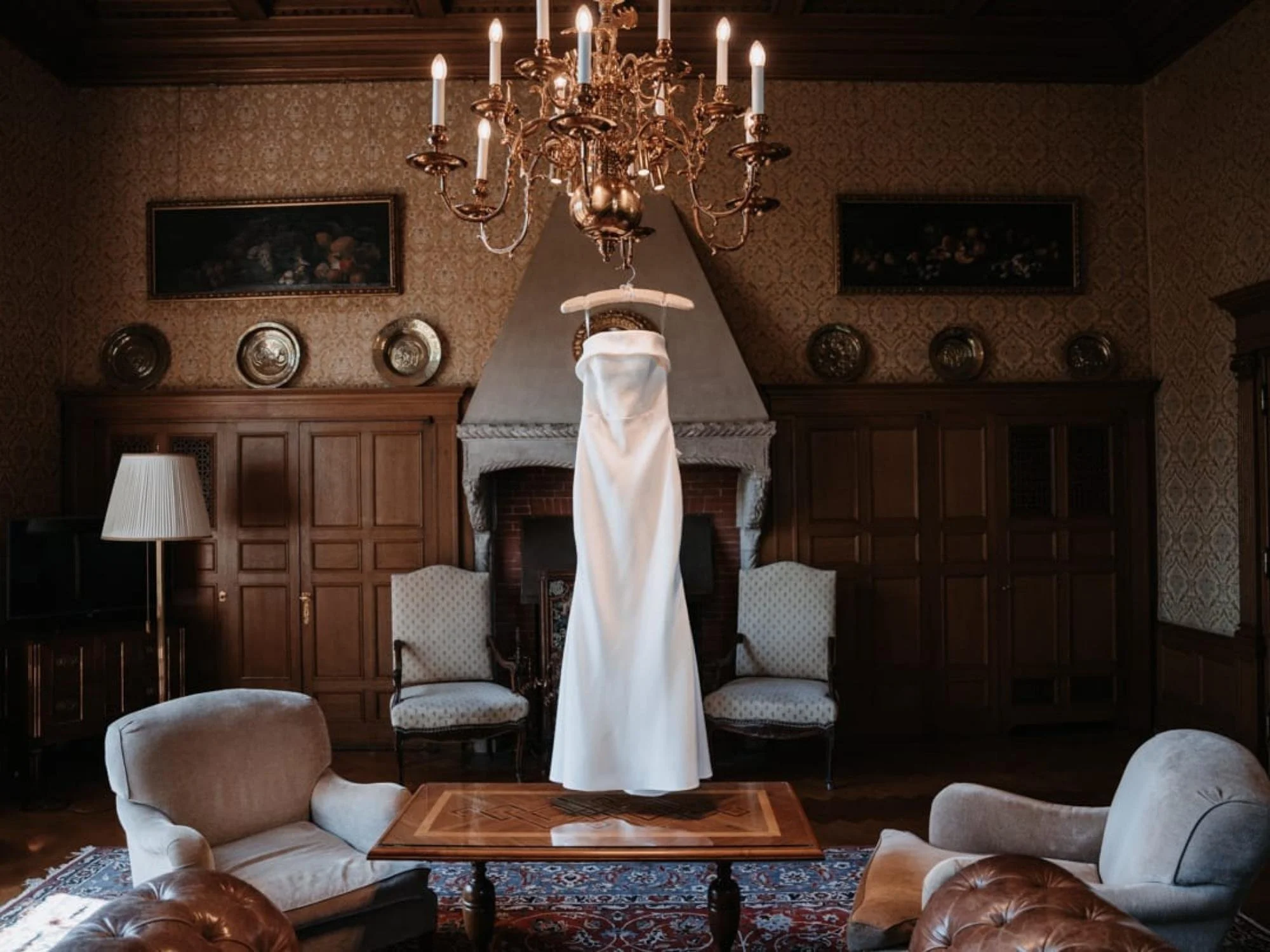 Brautkleid hängt vorbereitet am Kronleuchter in der Hochzeitssuite im Schlosshotel Kronberg – stilvolle Hochzeitsvorbereitung der Braut.