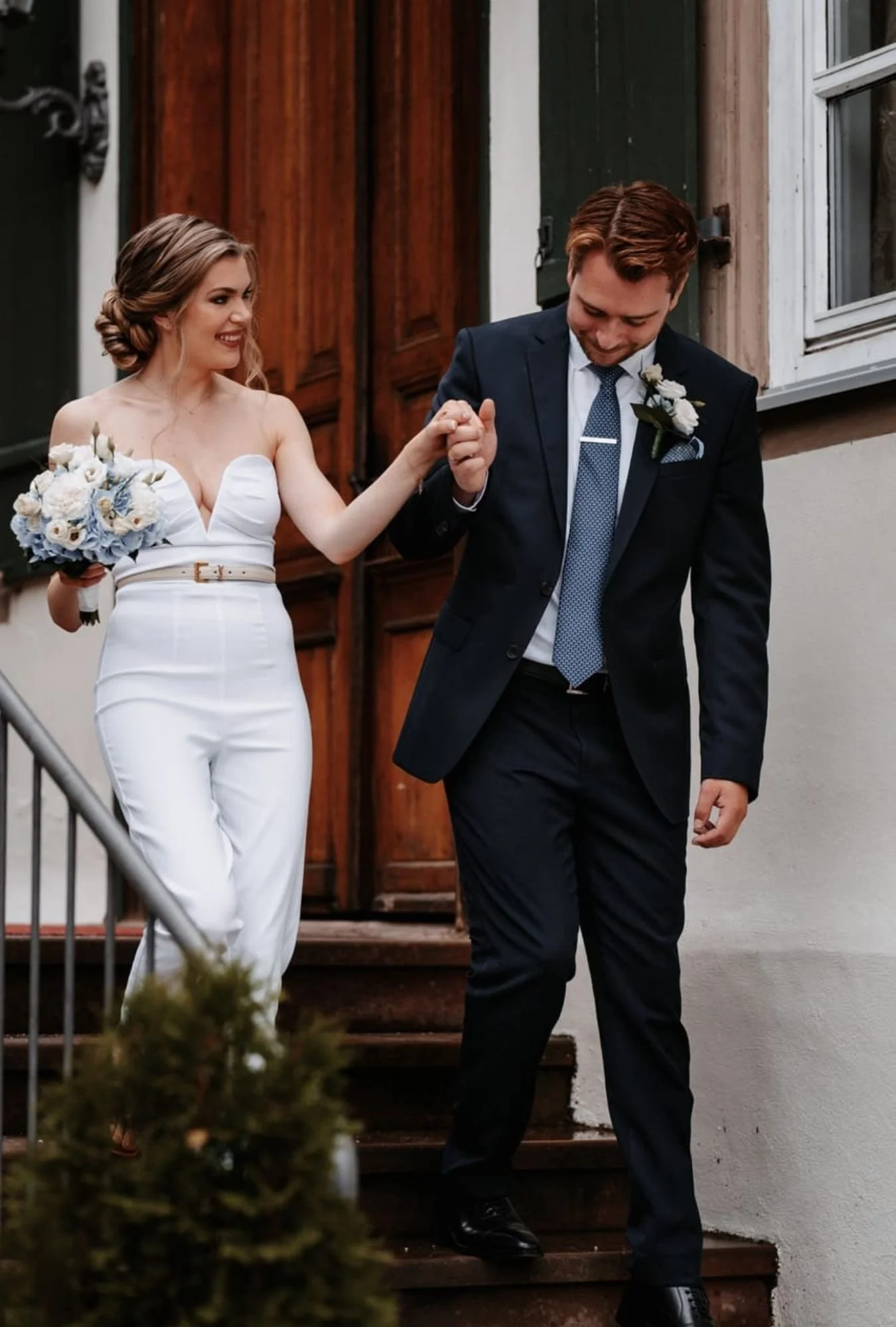 Braut und Bräutigam Hand in Hand gehen eine Treppe hinunter