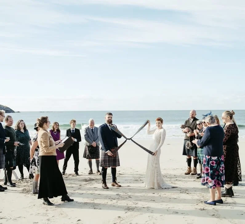Freie Trauung in Achmelvich, Schottland: Hochzeitspaar mit Gästen und Celebrant beim Tie the Knot an der Küste