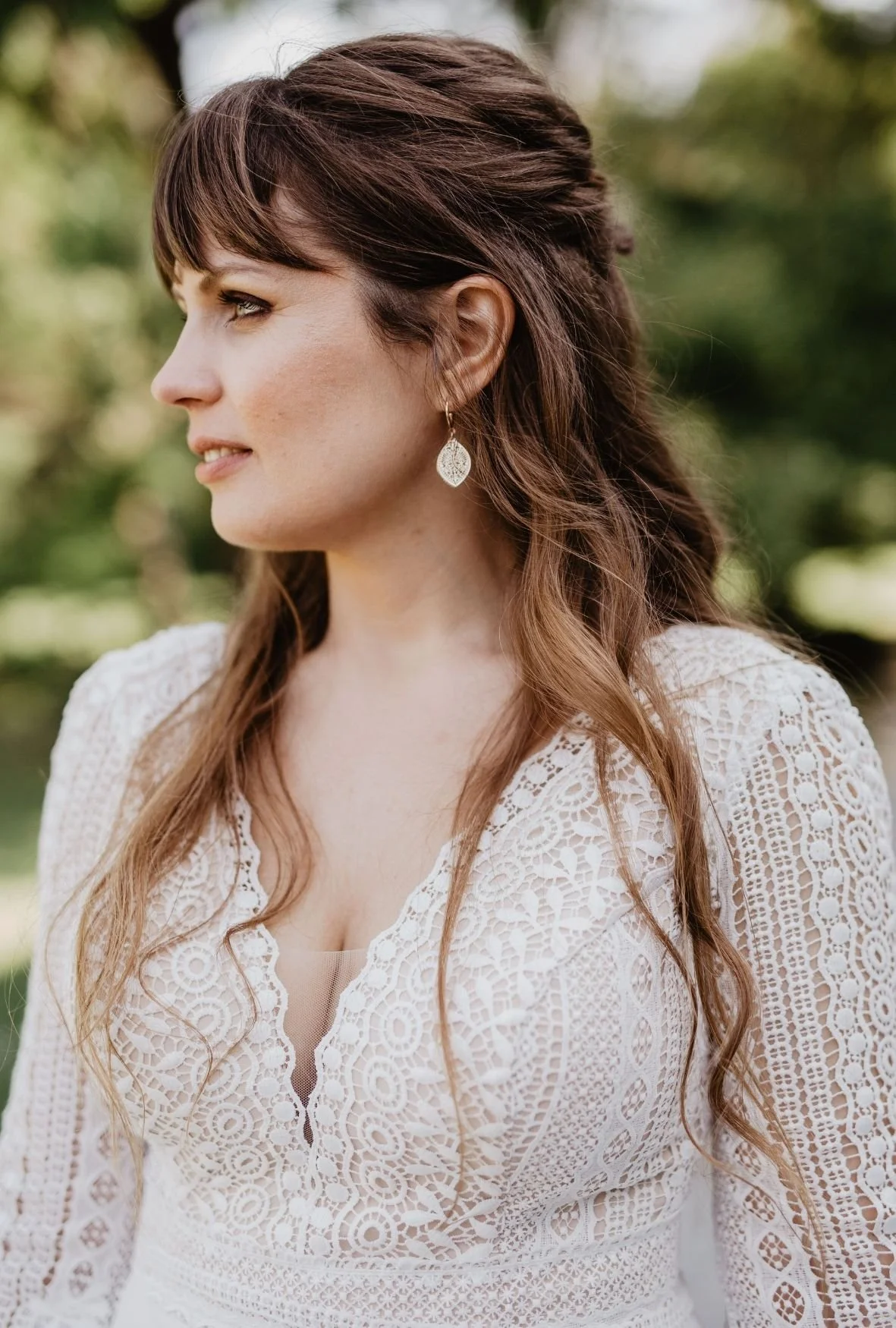 Braut im Profil mit sanftem Make-up und welligem Haar