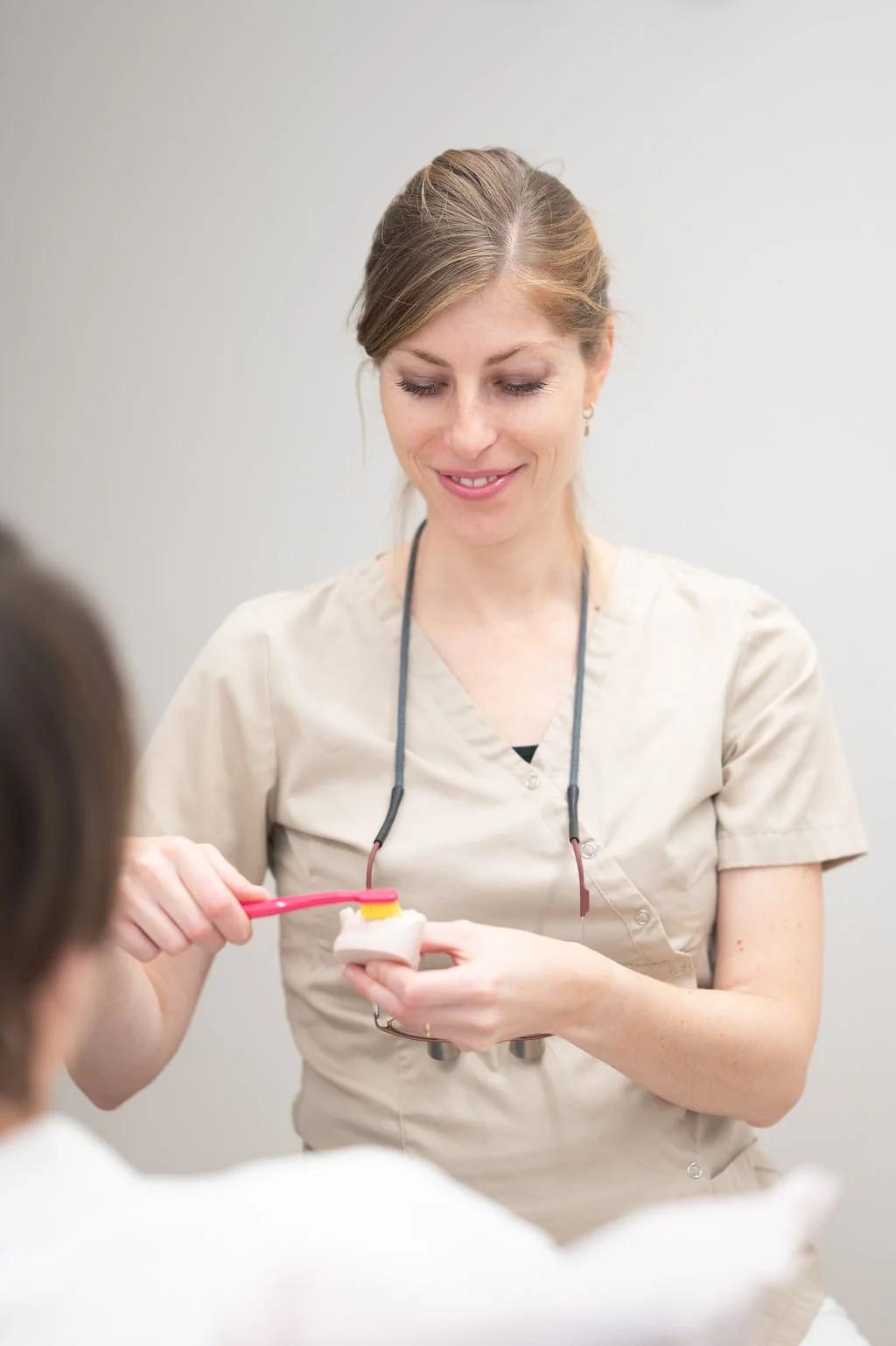 Mylène Kitselar-Wats mondhygiënist van Mondzorg Voorne in Oostvoorne een modelkaak en tandenborstel vasthoudt om mondverzorging uit te leggen.