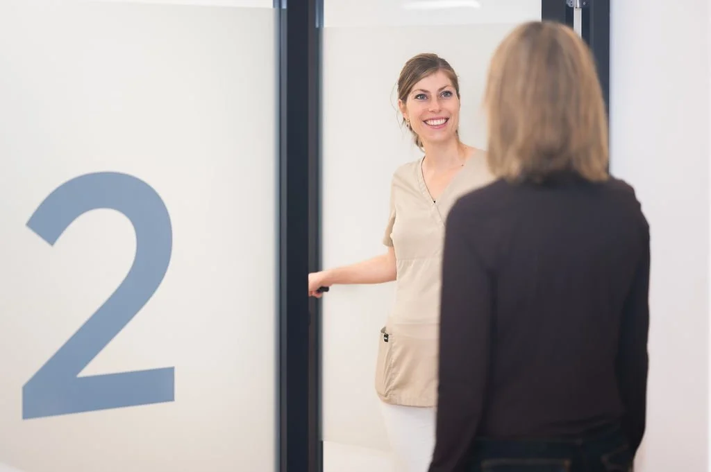 Eigenaar Mylène Kitselar-Wats, mondhygiënist bij Mondzorg Voorne, verwelkomt een nieuwe patiënt in de praktijk in Hellevoetsluis.