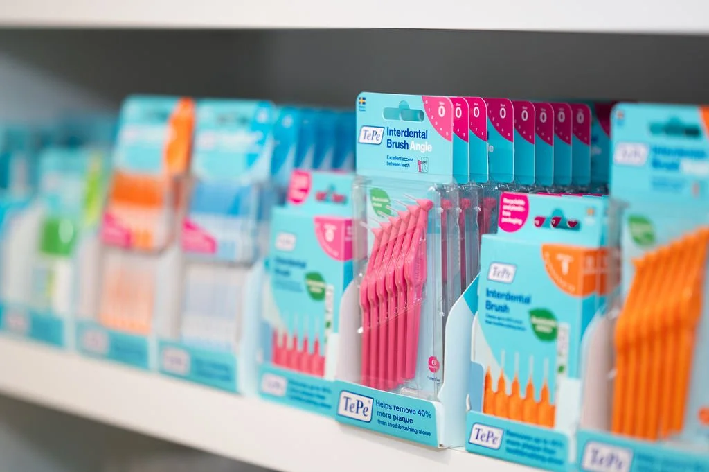 Verpakking van tandenborstelhoezen en een TePe Interdental Brush Angle op een winkelrek in de praktijken van Mondzorg Voorne in Oostvoorne en Hellevoetsluis.