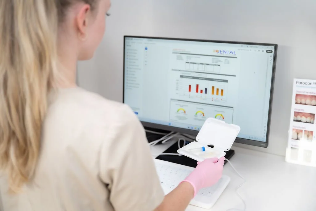 Mondhygiënist van Mondzorg Voorne in Hellevoetsluis en Oostvoorne bekijkt onderzoeksresultaten op een scherm en houdt een testset vast.