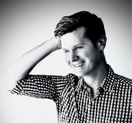 om Caulfield, Financial Controller at PTIX, smiling and wearing a checkered shirt