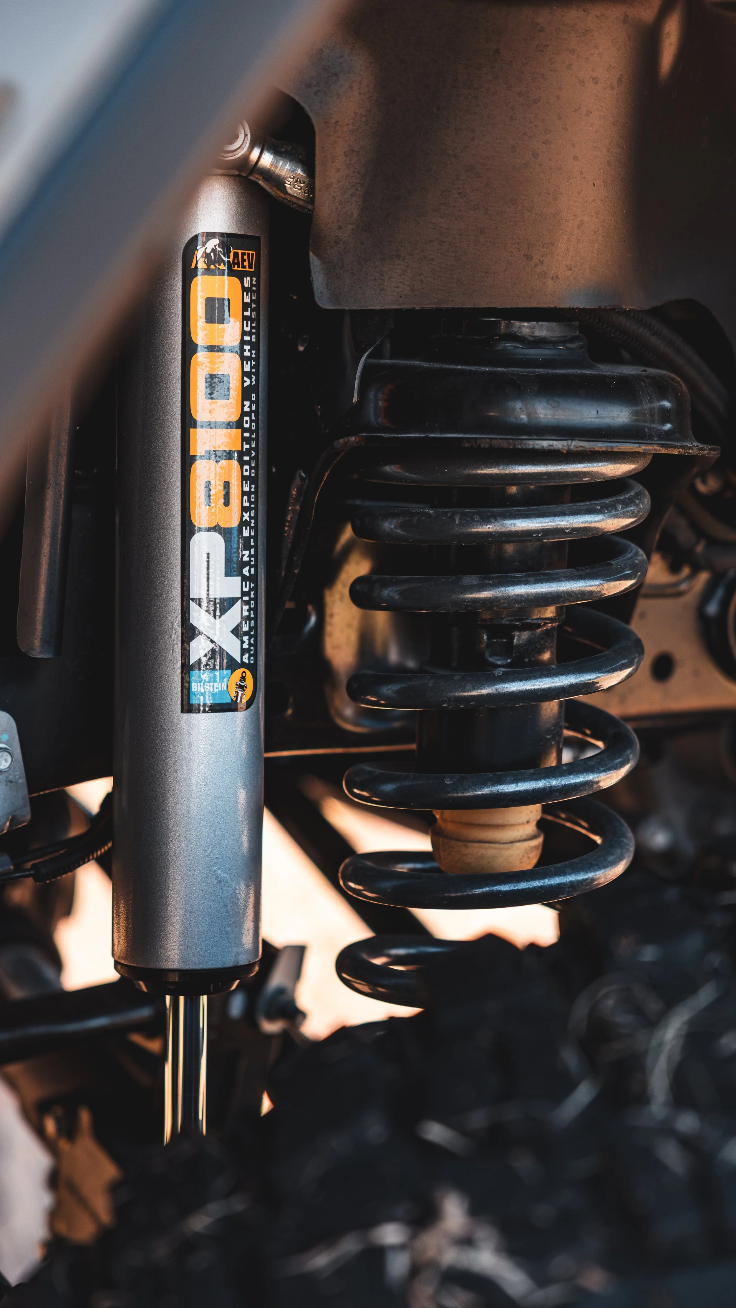 Close-up of a vehicle suspension system showing a coil spring and a shock absorber.