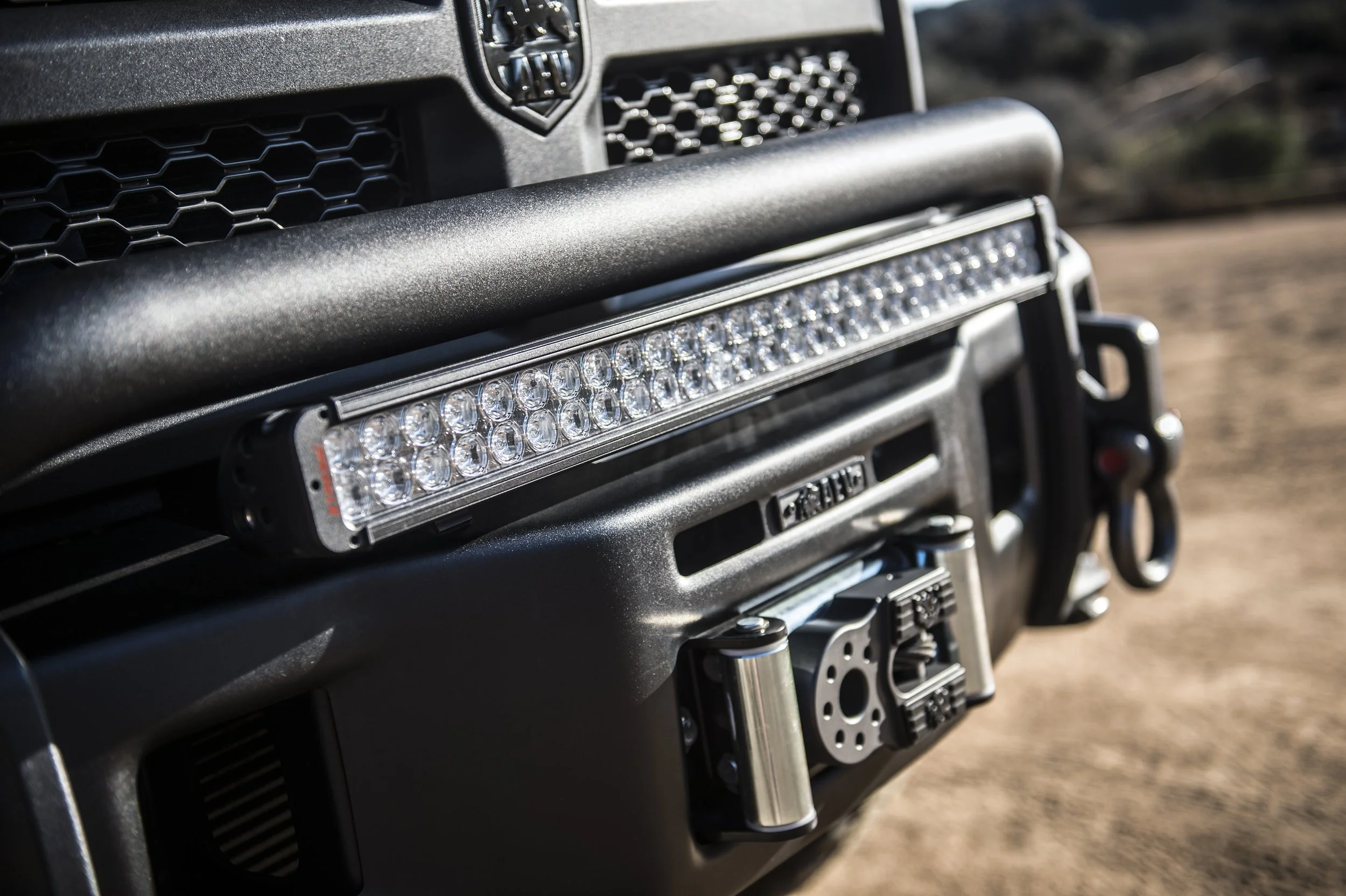 Close-up of a black Jeep dashboard with a mounted LED light bar and a winch