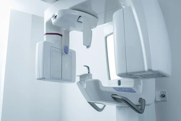 A panoramic dental X-ray machine in a clinic room.