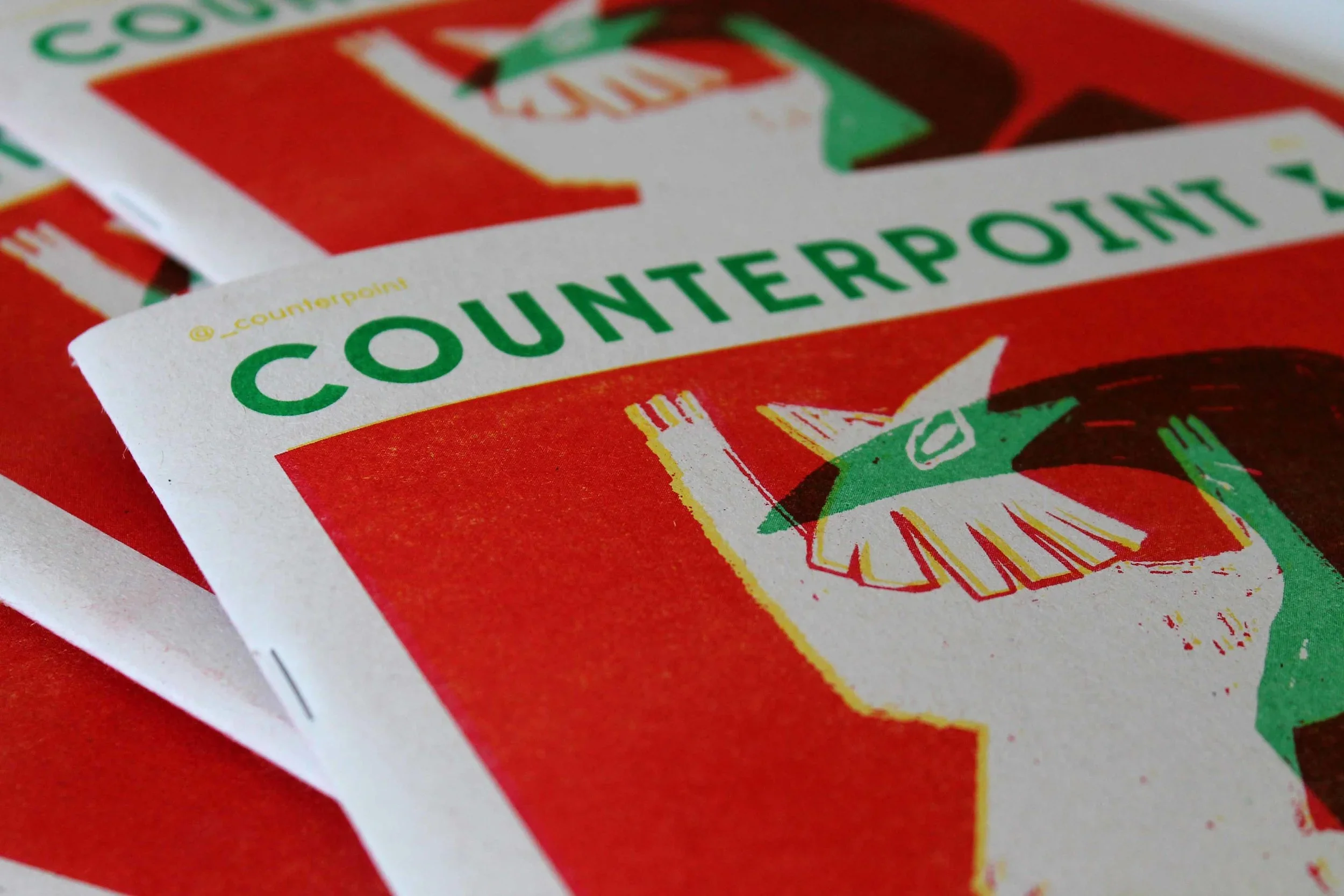Close-up of a red and white flyer or poster with green text and a stylized illustration of a hand holding a stash of money.