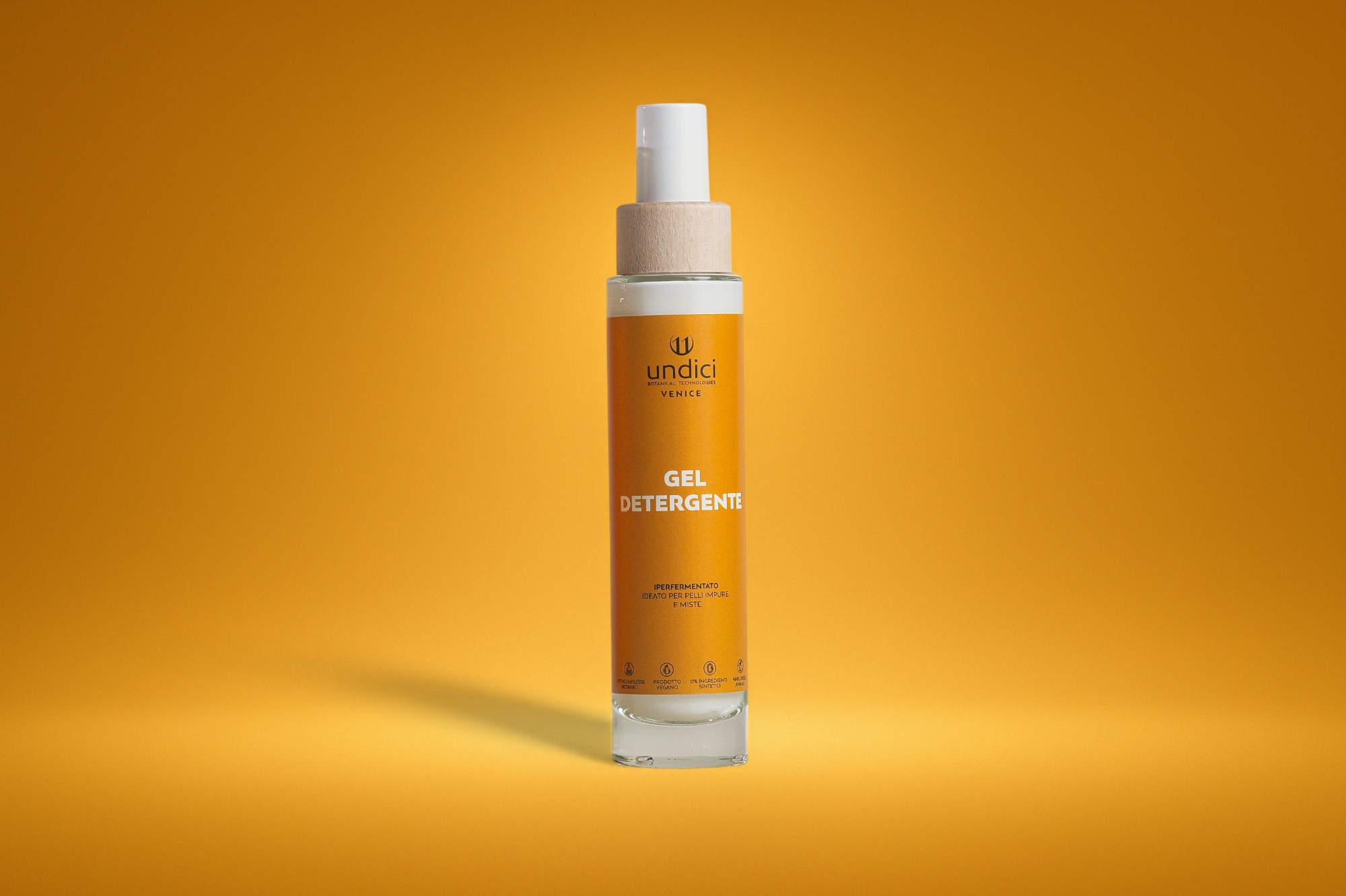 Bottiglia di gel detergente in primo piano contro uno sfondo giallo