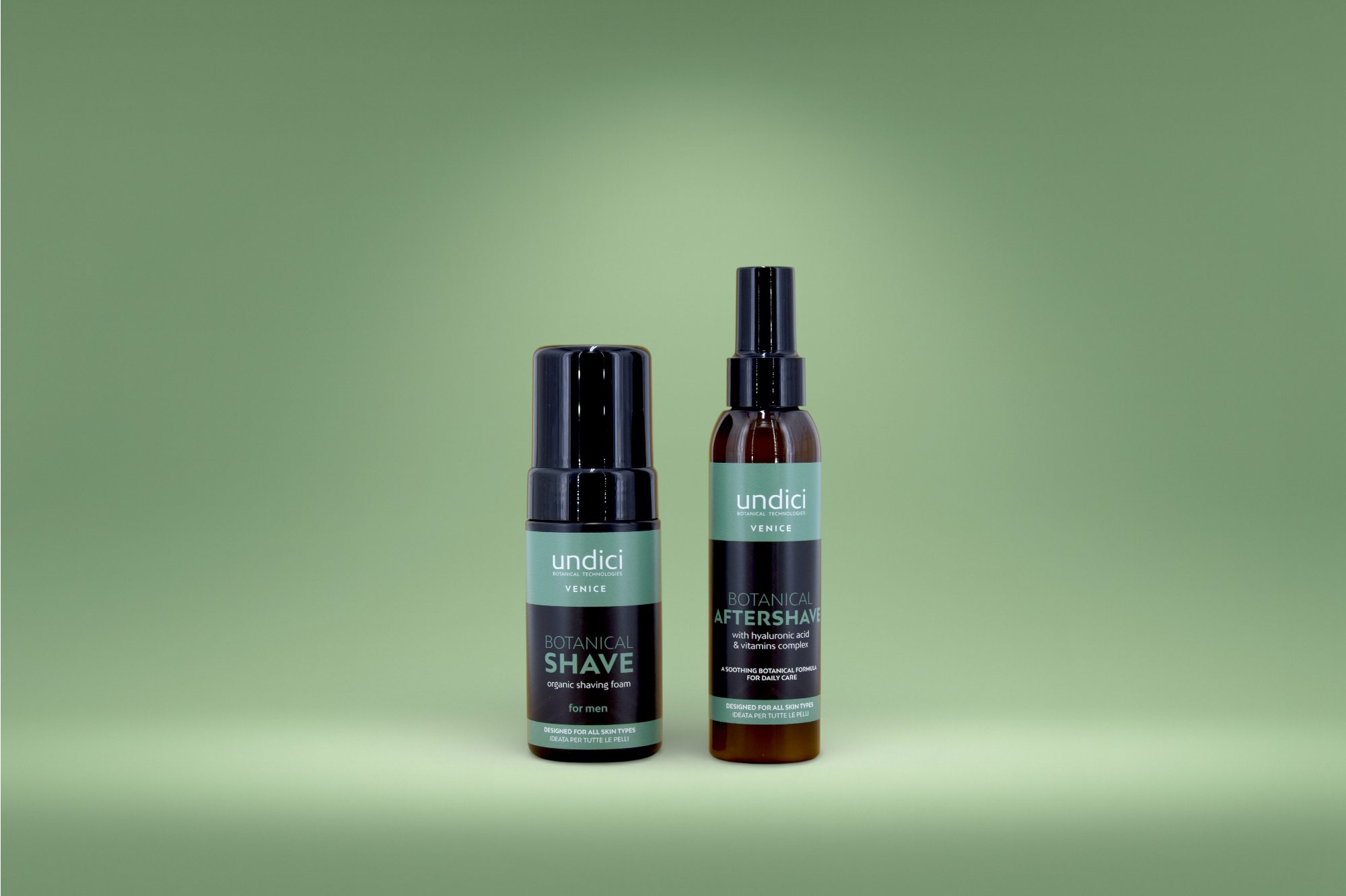 Due prodotti per la rasatura maschile: schiuma da barba organica e dopobarba, entrambi di marca 'undici', con etichette verdi e nere, posizionati contro uno sfondo verde chiaro.