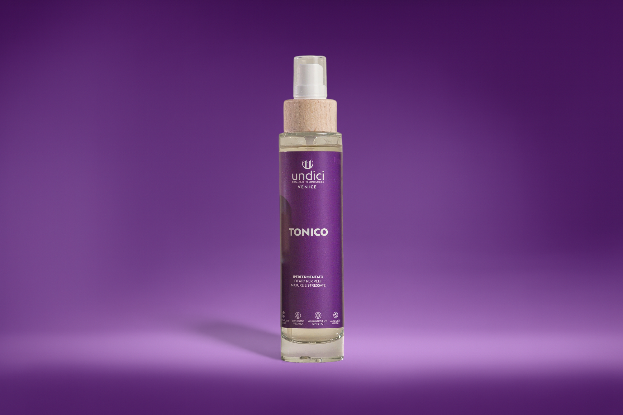 Flacone di tonico con etichetta viola e logo di undici, sfondo viola