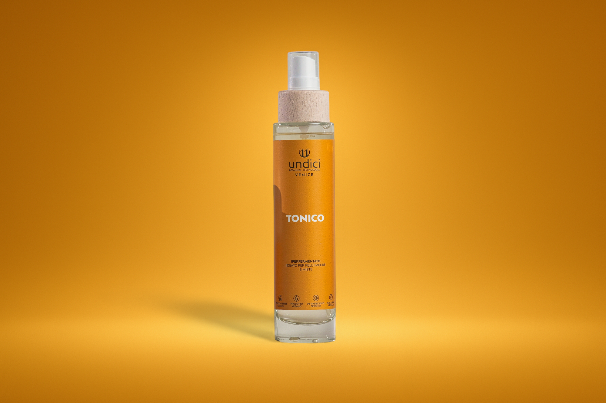 Bottiglia di tonico per la pelle con etichetta arancione, sfondo arancione