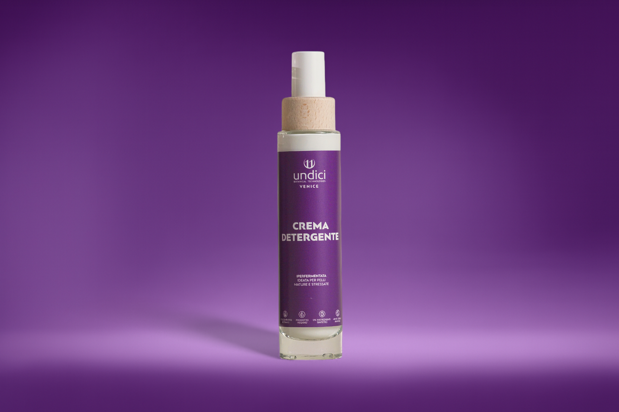 Bottiglia di crema detergente con etichetta viola, sfondo viola sfumato.