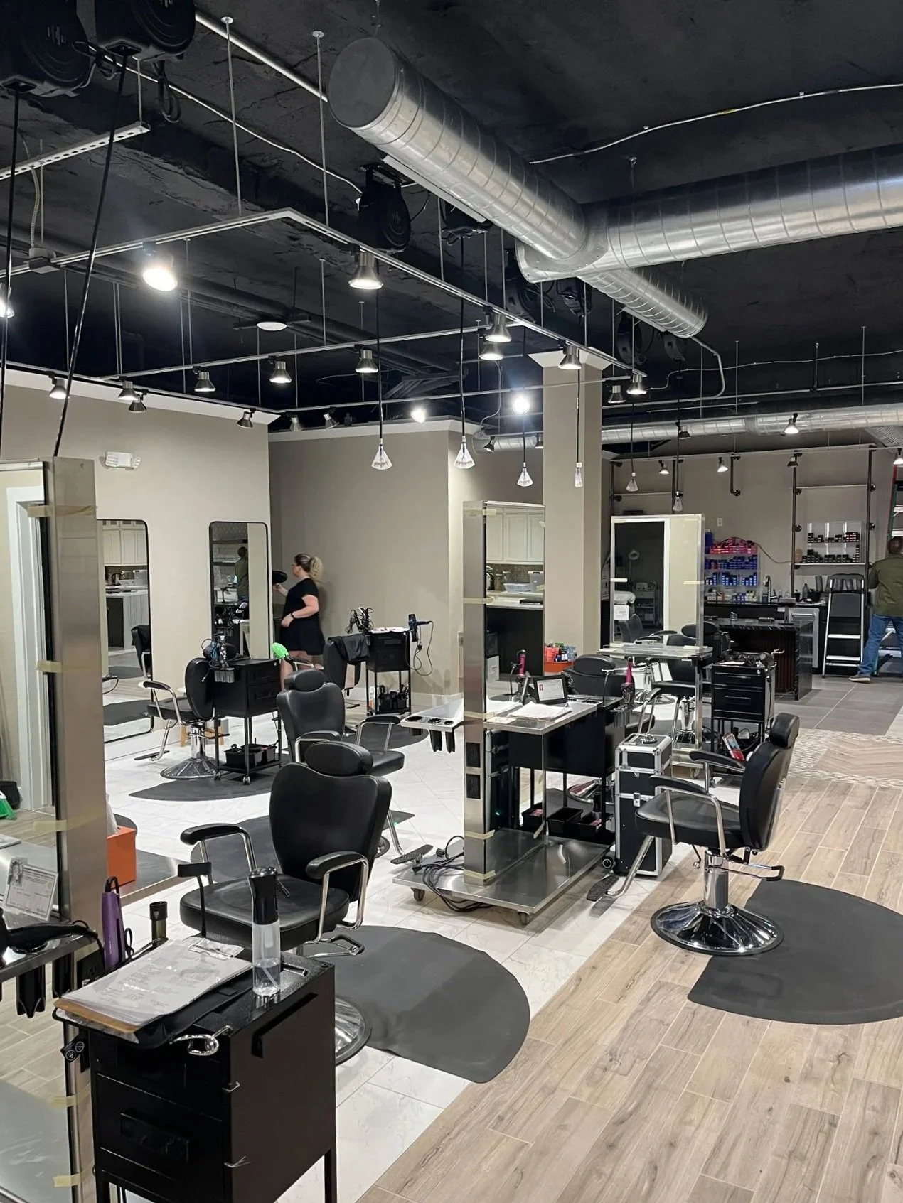 Interior of a modern hair salon with multiple styling chairs, mirrors, and hairdressing stations.