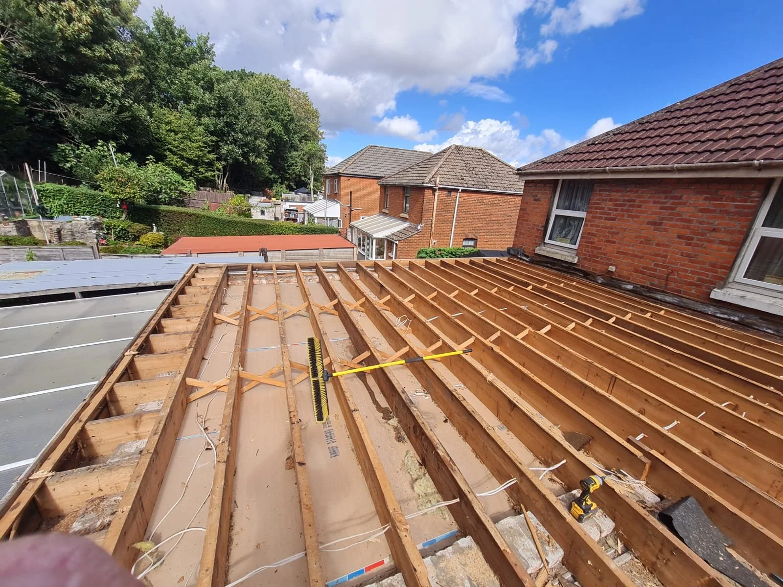 Flat roof joists exposed during a full roof replacement on a residential property