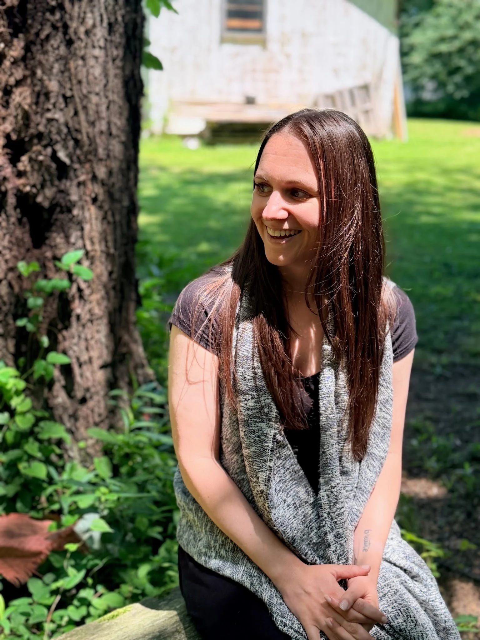 Image of Julie Iuliano, smiling with a tree, grass and barn in the background